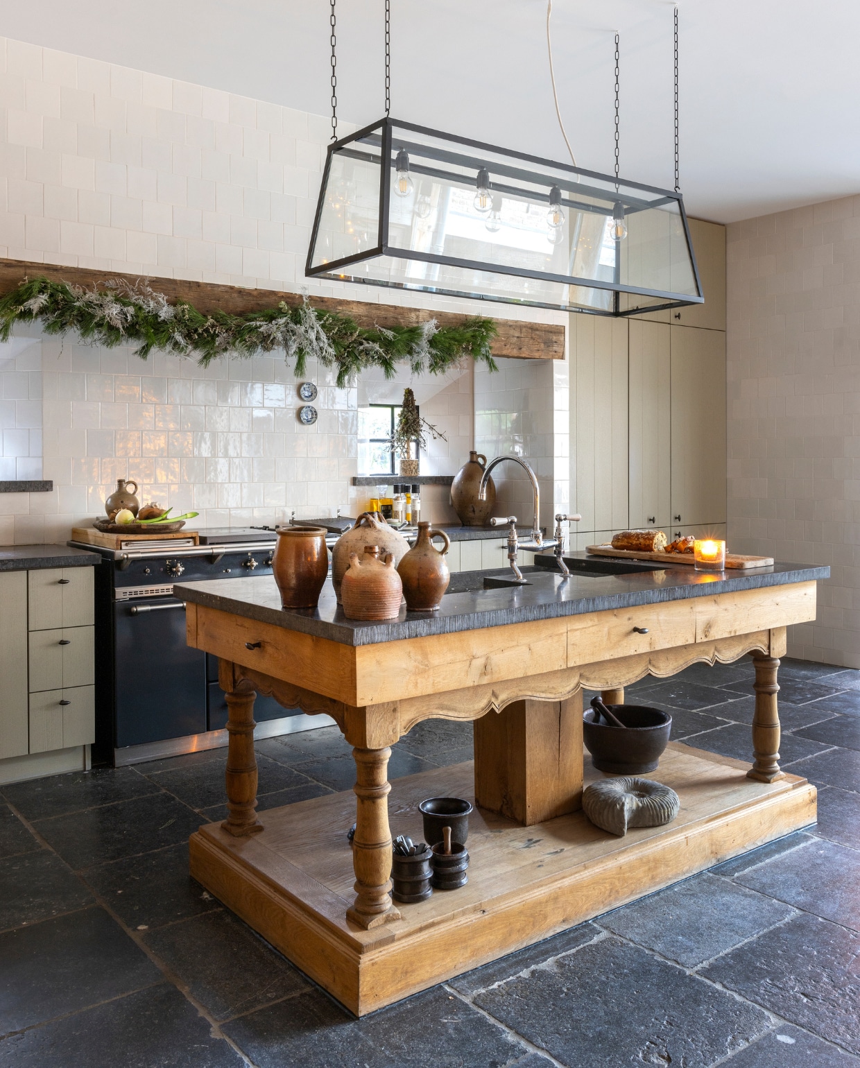 De oude eiken balk boven het aanrecht is van ’t Achterhuis. Net als het aanrechtblad van Belgische hardsteen, dat op maat is gezaagd in het natuursteenatelier van ’t Achterhuis. Het is dezelfde steen als de vloertegel. De keuken is ontworpen door Sarah en Frank en werd met de hand gemaakt voor ’t Achterhuis. Op de wand Hollandse witjes Achterhuis-mix. Ook de lamp is een eigen ontwerp en werd gemaakt door de smid van ’t Achterhuis. Het watereiland is van een oude tafel gemaakt. Bij de antieke wasbak staat een kraan van Lefroy Brooks, hiervan is ’t Achterhuis De oude eiken balk boven het aanrecht is van ’t Achterhuis. Net als het aanrechtblad van Belgische hardsteen, dat op maat is gezaagd in het natuursteenatelier van ’t Achterhuis. Het is dezelfde steen als de vloertegel. De keuken is ontworpen door Sarah en Frank en werd met de hand gemaakt voor ’t Achterhuis. Op de wand Hollandse witjes Achterhuis-mix. Ook de lamp is een eigen ontwerp en werd gemaakt door de smid van ’t Achterhuis. Het watereiland is van een oude tafel gemaakt. Bij de antieke wasbak staat een kraan van Lefroy Brooks, hiervan is ’t Achterhuis