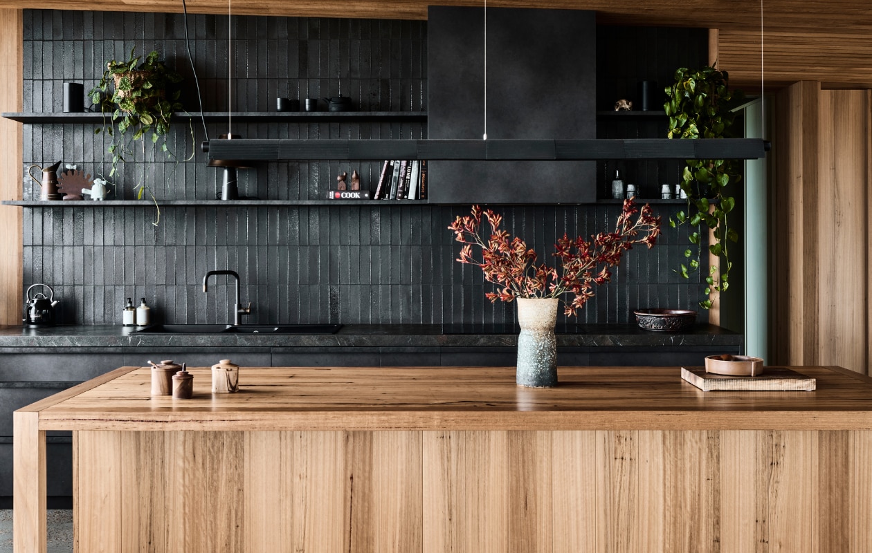Plafond en keukeneiland zijn gemaakt van brandwerend massief blackbutt. Hanglamp South Drawn. stijlvol wonen 08-2024 | productie Living agency | fotografie Tom Blachford
