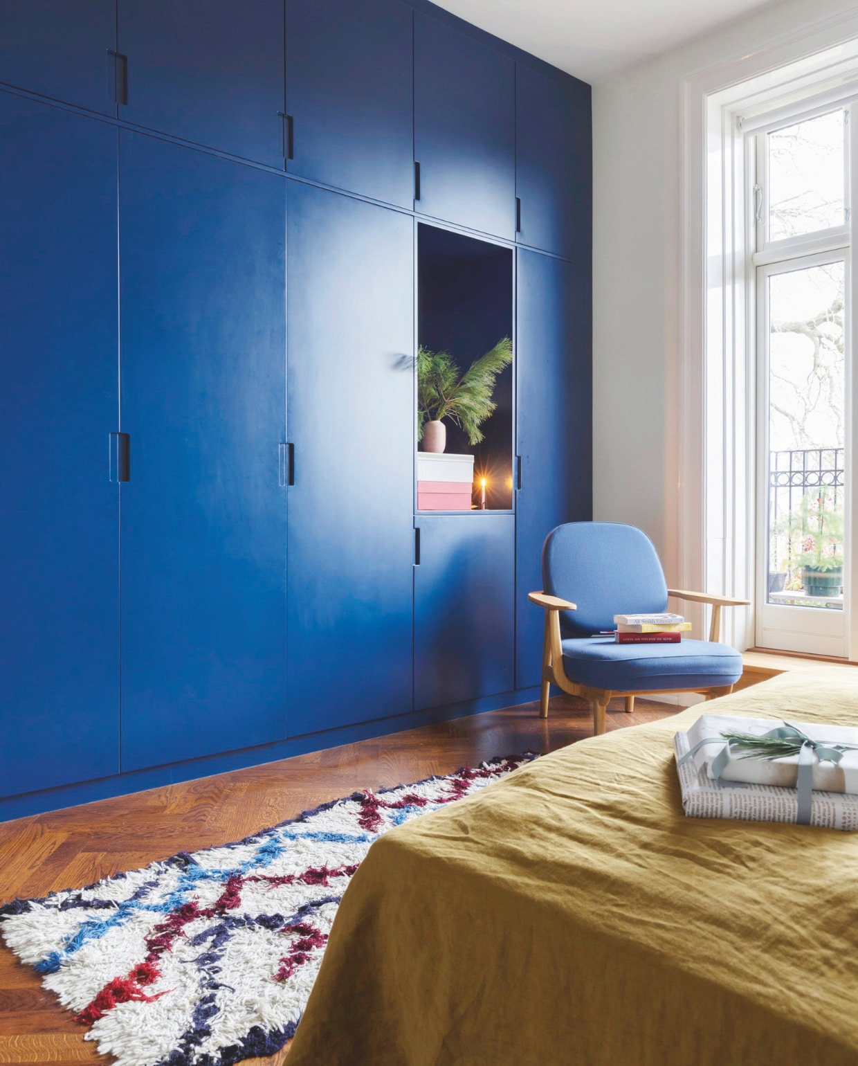 Studio Thinkwood ontwierp de royale inbouwkasten in de slaapkamer op maat naar een idee van Jette. Het opvallende blauw is Berliner Blå nr. 22 van Flügger Farben, stoel Fred van Jaime Hayon van Fritz Hansen, vloerkleed By Fribert. vtwonen 12-2024 | styling Rikke Graff Juel | fotografie Christina Kayser