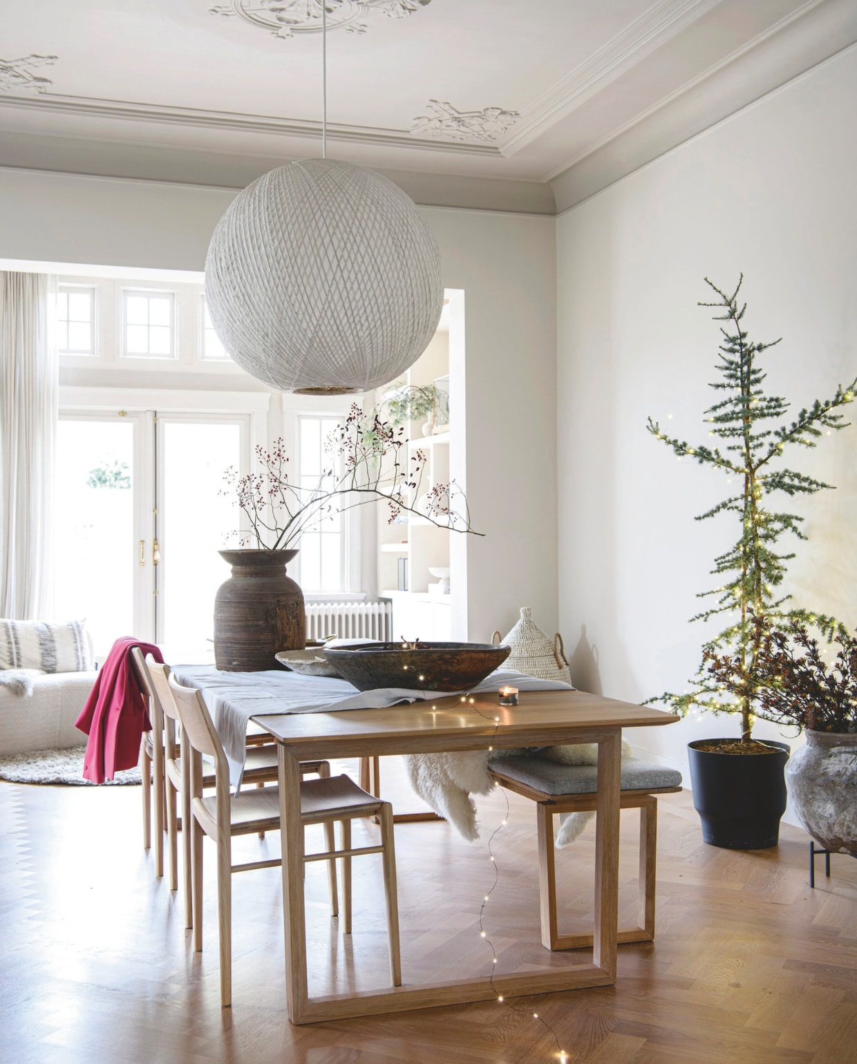 Eettafel, bankje, stoelen, kussen Bolia. Houten vaas en schaal Household Hardware, hanglamp flinders.nl, mand H&amp;M Home. Wandkleur Skimming Stone 241, plafond, kozijnen en tuin- deuren Elephant’s Breath 229 van Farrow &amp; Ball. vtwonen 12-2024 | styling Marit Saladini | fotografie Louis Lemaire