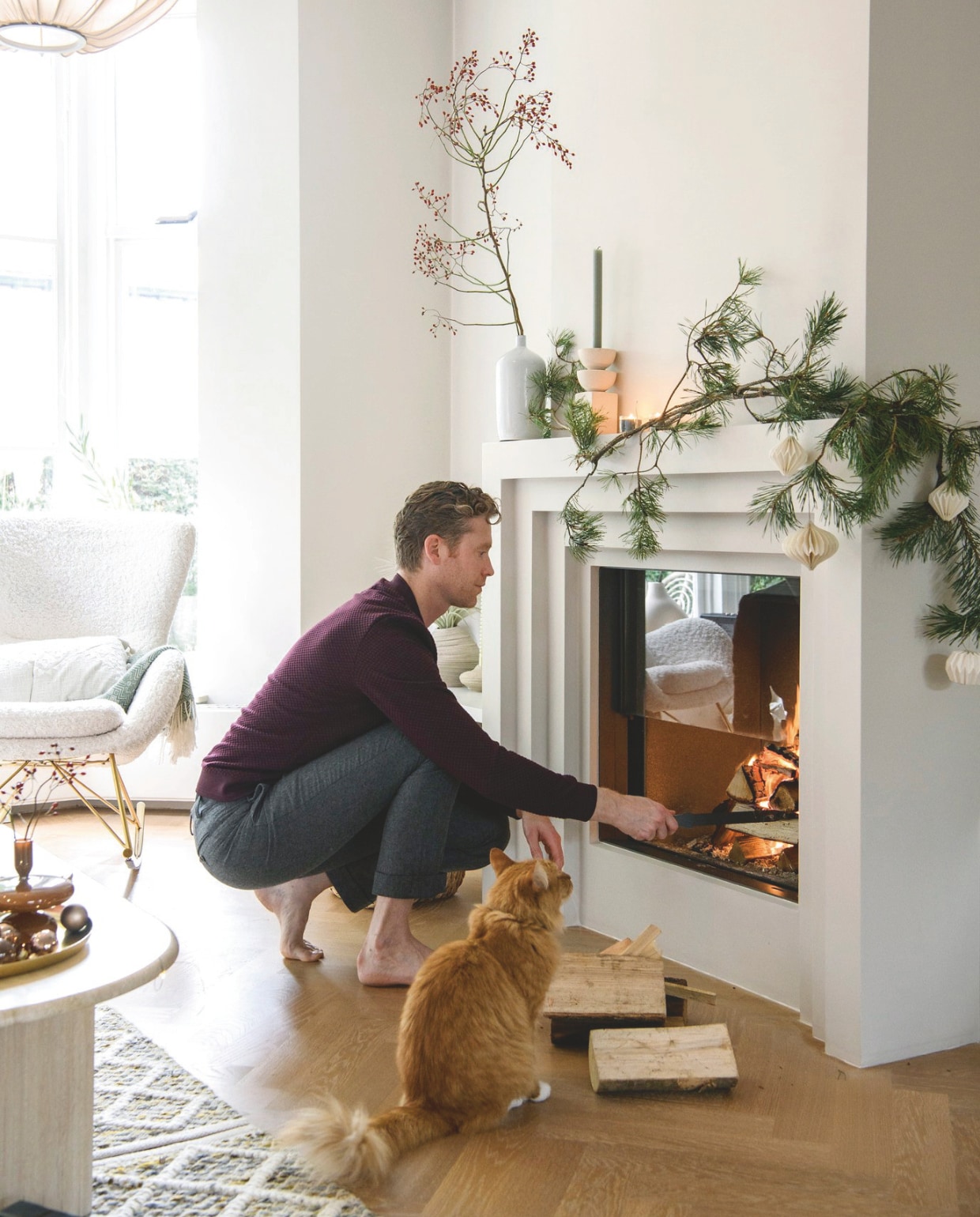 Art-decoschouw op maat gemaakt, houtkachel Kalfire Fireplaces. Schommelstoel Westwing, salontafel Marktplaats, vloerkleed Sissy-Boy Homeland, hanglamp Bolia, vaas, kandelaars H&amp;M Home, kerstdecoratie H&amp;M Home, Søstrene Grene. vtwonen 12-2024 | styling Marit Saladini | fotografie Louis Lemaire
