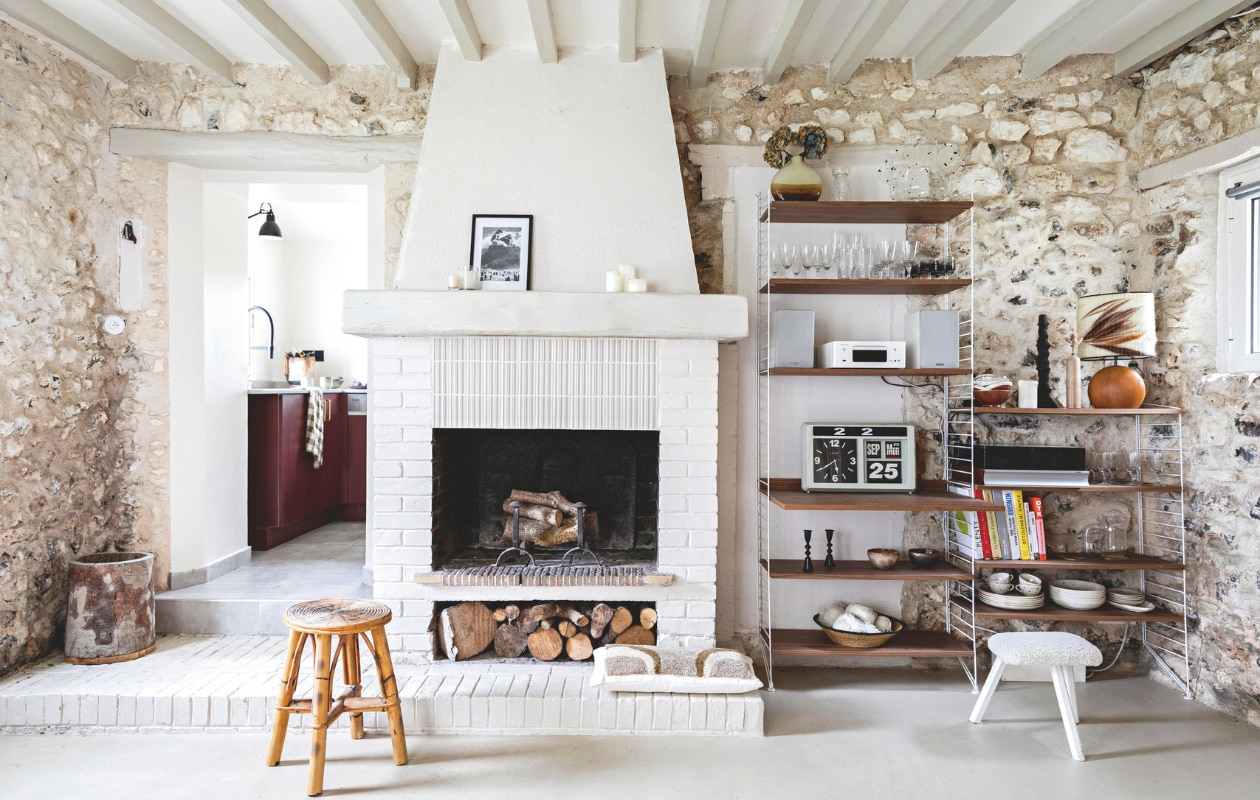 Vloer gepolijst beton, rotan kruk via Selency. Wollen kussen Bed and Philosophy. Muurkleur keuken Natural Rice van Pure &amp; Original, keuken Ikea met op maat gemaakte deuren. vtwonen 13-2024 | styling Marie-Maud Levron | fotografie Yann Deret