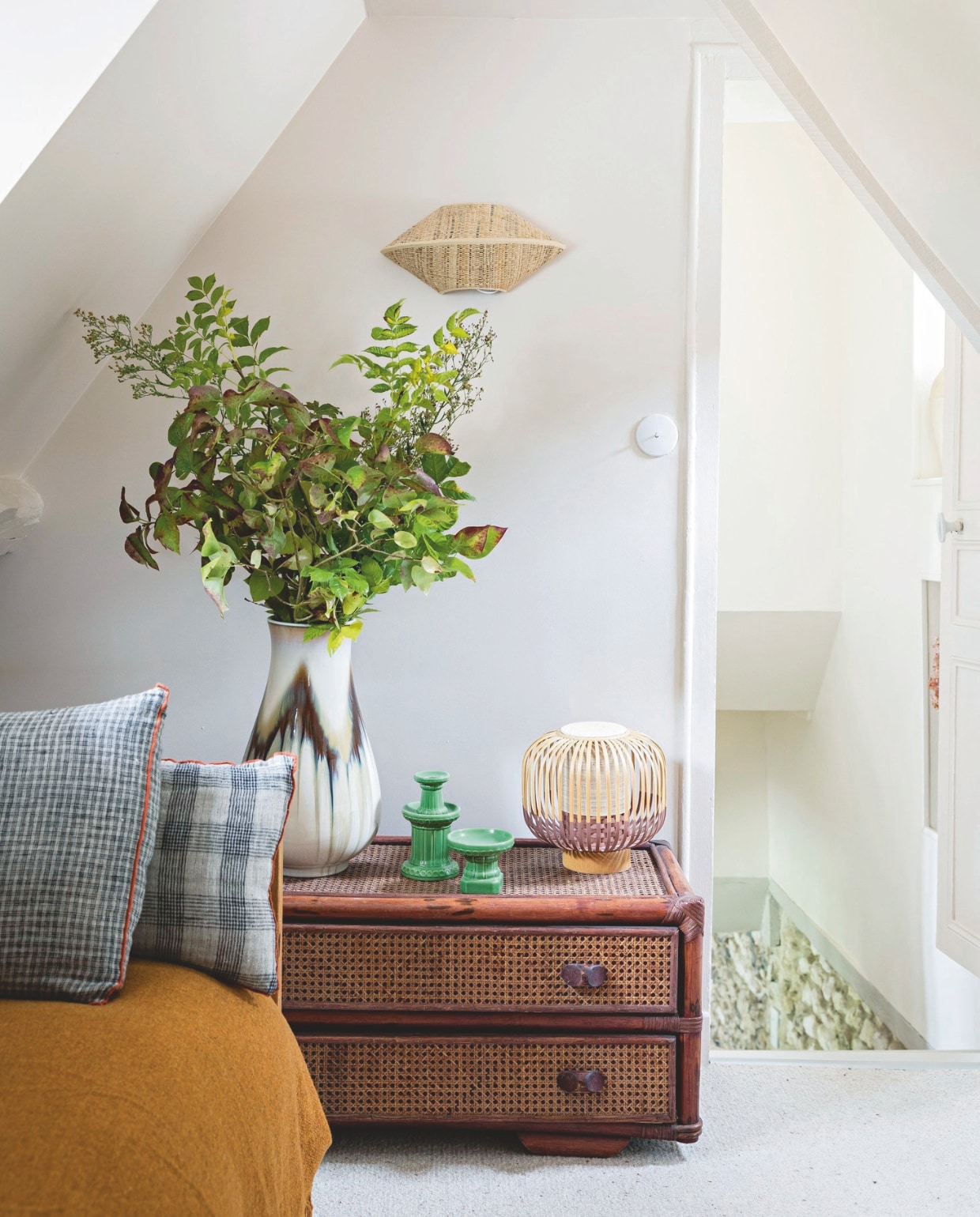 Lage ladenkast en vaas via Selency. Wandlamp Socialite Family, grijs geruite en gestreepte kussens Le Monde Sauvage. Deken Maison de Vacances. vtwonen 13-2024 | styling Marie-Maud Levron | fotografie Yann Deret