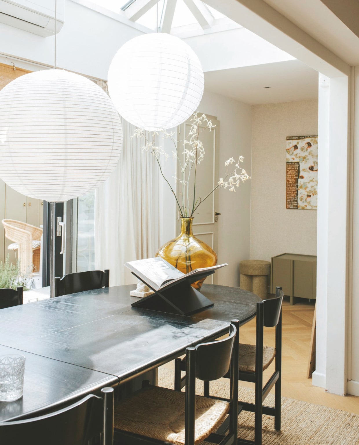 Verfkleur deur Old White Farrow & Ball. Muurkleur IG KH K1030 Karwei. Eettafelstoelen vintage Pastoe, eettafel vintage Skovby, via Marktplaats. Flesvaas erfstuk. Vloerkleed Lohals van Ikea. Grote rijstpapieren lamp Hay. Kleine rijstpapieren lamp bol.com. Rolgordijnen Color&Co.Kunstwerk van oma Valerie. Lage kast Woood. vtwonen binnenkijkspecial 11-2024 | fotografie Merel Annabel Visscher