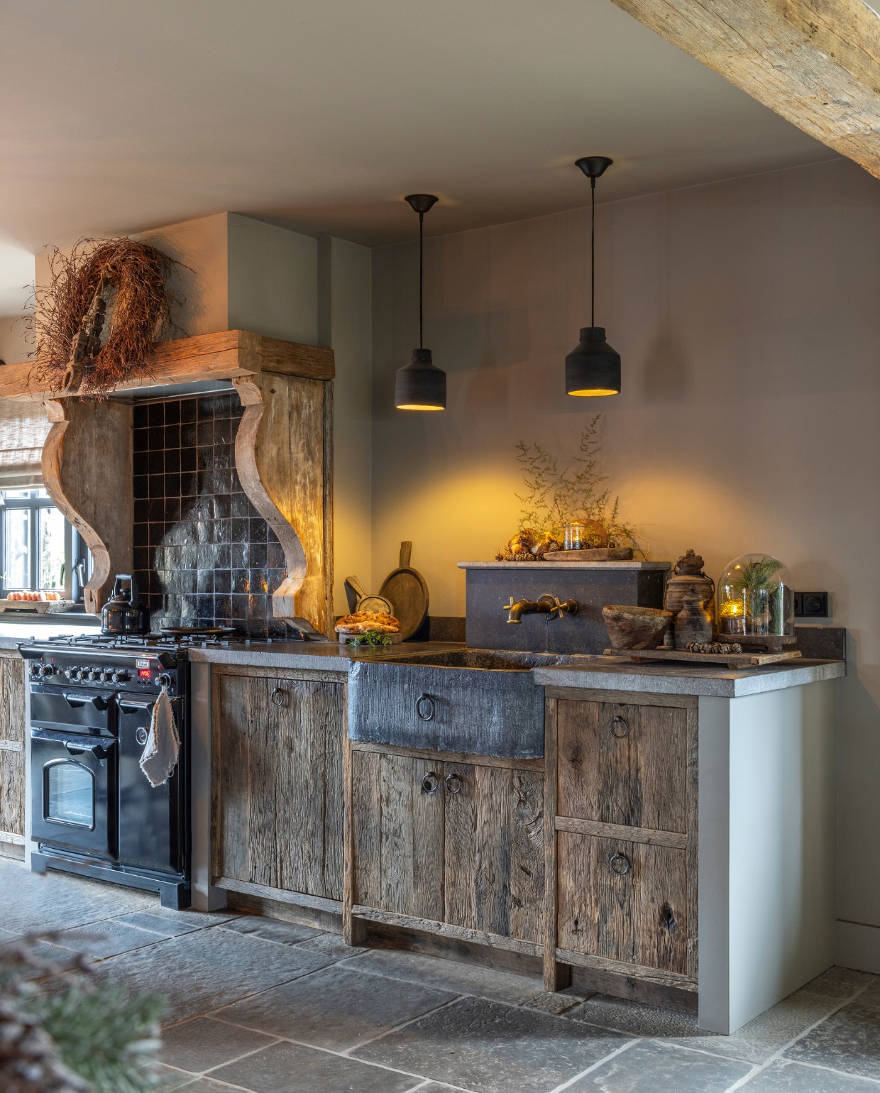 De keuken is ontworpen en gerealiseerd door René Houtman. Het blad is van Belgisch hardsteen. De hanglampen van Hoffz kocht Diana bij Frieda Dorresteijn. De wanden zijn geverfd met kalkverf van Carte Colori in de kleur Gritti. Op de vloer liggen Castle Stones in de kleur Old Grey, geleverd door De Wilgengaarde. vtwonen landelijk 07-2024 | Fotografie Anneke Gambon