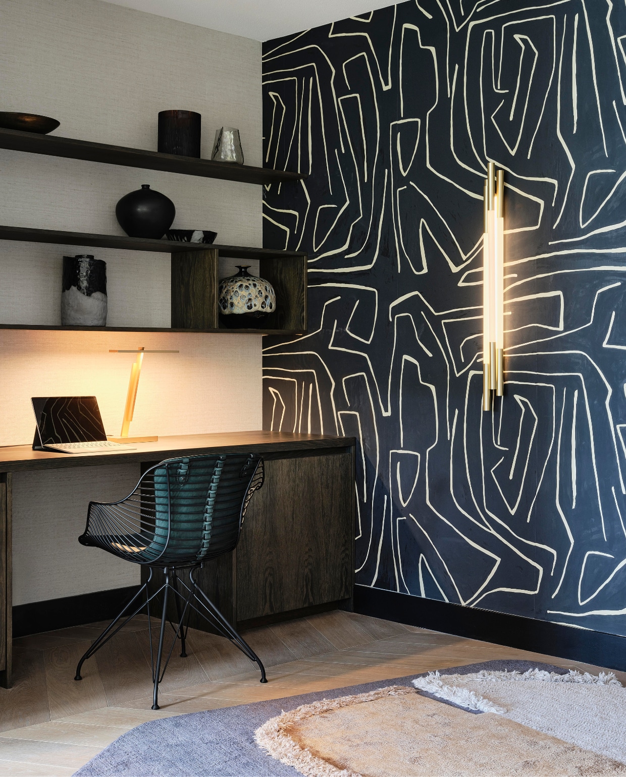 Linda: ‘De Eames lounge chairs namen de eigenaars mee uit hun andere woning. Ik gaf ze meer karakter met de schapenvellen.’ Grafitto behang Kelly Wearstler, bijzettafel Maxalto, stalen bureaustoel Overgaard &amp; Dyrman. stijlvol wonen 08-2024 | Fotografie Space Content Studio