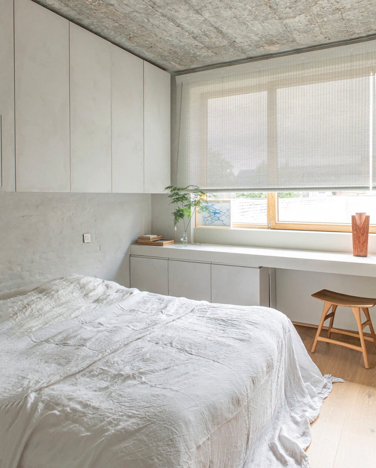 Bedlinnen Marie-Marie, maatwerk wandkast en werkblad CNC, houten kruk Osso van Ethnicraft, raambekleding Woven Wood van Zonnelux, vlekvrije parketvloer Wood for Life van QuickStep, het plafond van ruw beton is onafgewerkt gelaten. vtwonen 13-2024 | styling Jeske Weel | fotografie Caroline Coehorst