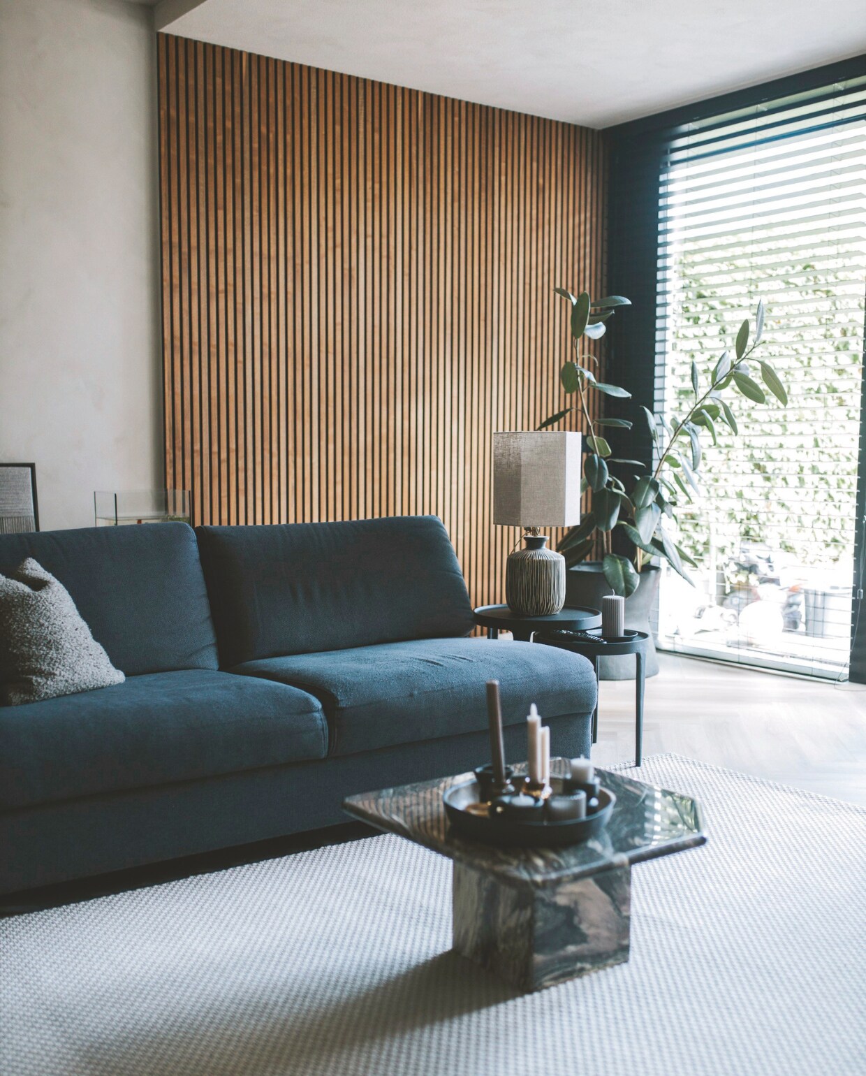 Bank Basic Label. Marmeren salontafel Curated Collectables via Marktplaats. Bijzettafels Tobias van Light &amp; Living. Lamp Madame Garage. Wandpanelen Walnut van WoodUpp. Bloempot Serax. Raambekleding Veneta. Vloerkleed is een outdoor kleed van Ikea. Pvc-vloer van Floer. vtwonen binnenkijkspecial 11-2024 | fotografie Merel Visscher
