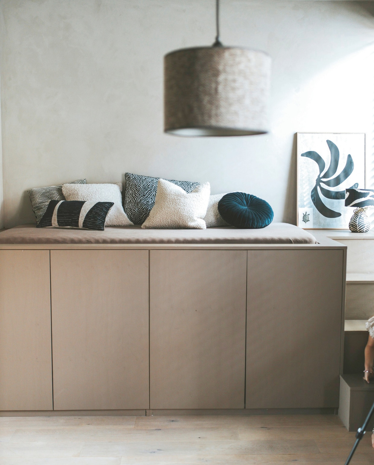 Kast van Ikea omgebouwd tot loungeplek. Witte kussens Zara Home, kussen met fijne zwarte print Intratuin, rond kussen Kwantum, handgemaakt kussen Daisy Buijs. Lamp Madame Garage. vtwonen binnenkijkspecial 11-2024 | fotografie Merel Visscher