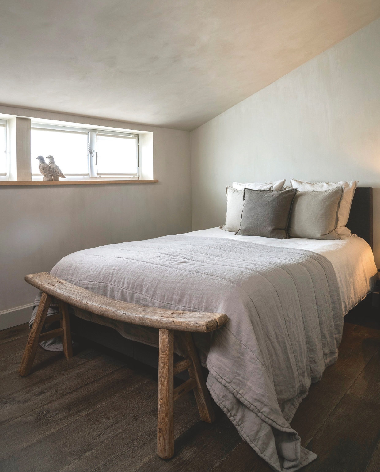 De muur in de slaapkamer is geschilderd in de kleur Old Linen van Pure &amp; Original. Bankje voor het bed van Aura Peeperkorn, beddengoed van Casa Comodo. vtwonen landelijk 08-2024 | fotografie Jonah Samyn