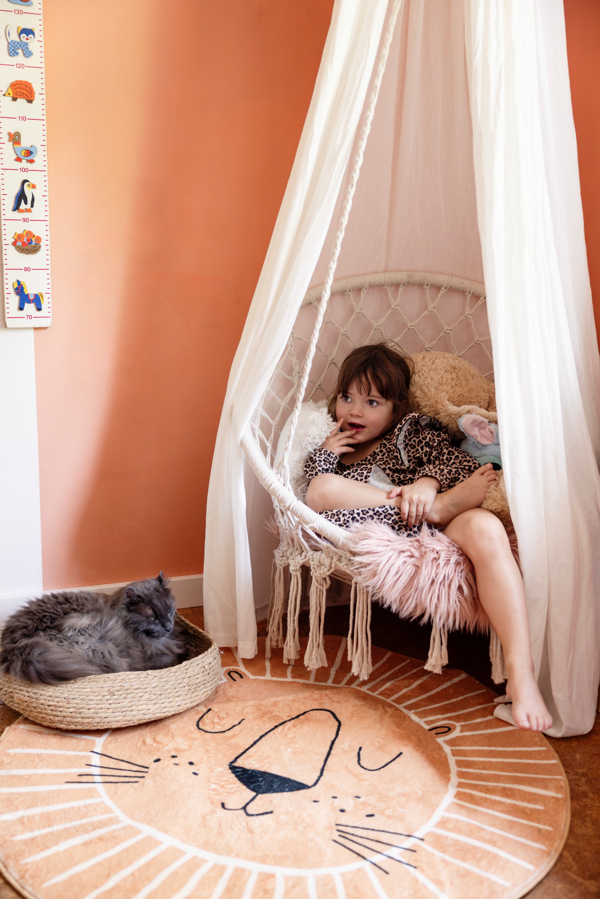 Roze tint voor wand zelf gemengd met restjes verf, hangstoel Action, klamboe genaaid door Jannekes moeder, vloerkleed en kattenmand Temu, kindermeetlat kringloop. vtwonen 02-2025 | styling Ilona Jongepier | fotografie Dana van Leeuwen | tekst Chris Muyres