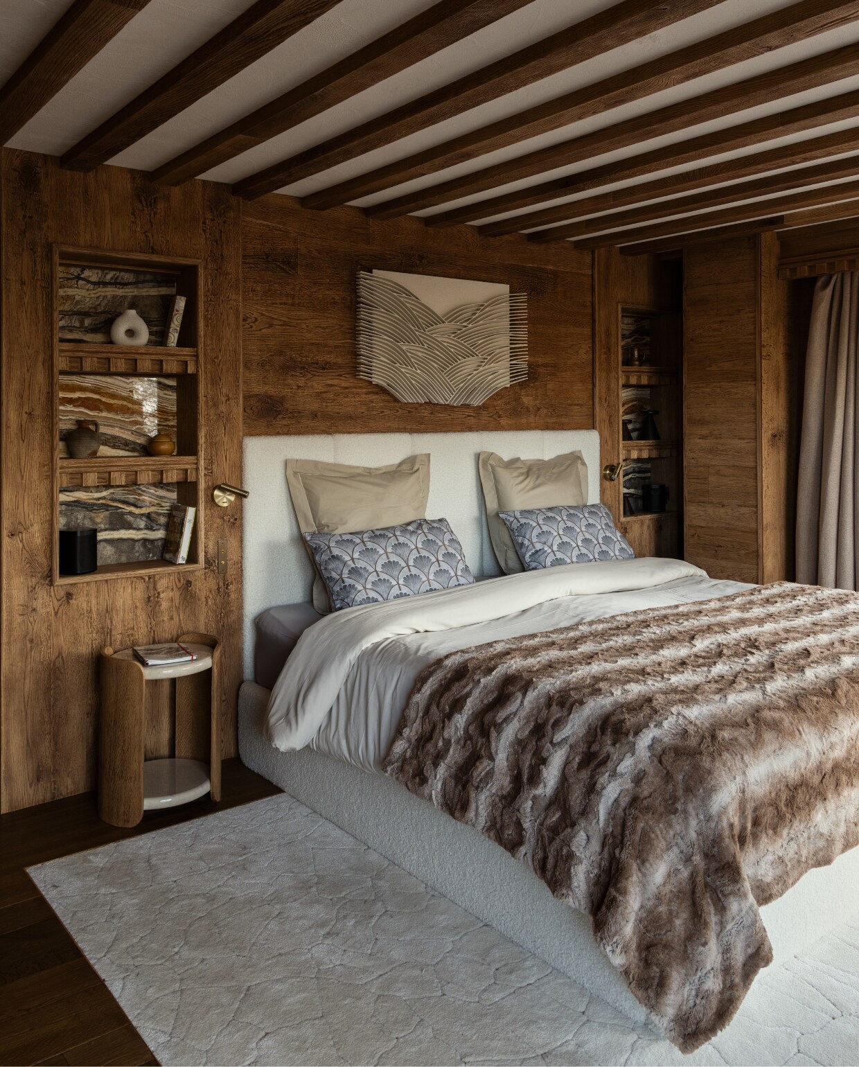 Een van de twee grote slaapkamers. Boven het bed hangt de sculptuur Mountains, gemaakt van zandpigment door kunstenaar René Galassi. Messing leeslampen Gamma van Josep Patsi. Het overige is maatwerk - het meubilair, het vloerkleed en de nissen van marmer Dark Emperador en hout - ontworpen door AS Interior Design. stijlvol wonen 08-2024 | Productie Living Inside | Fotografie Ramona Balaban