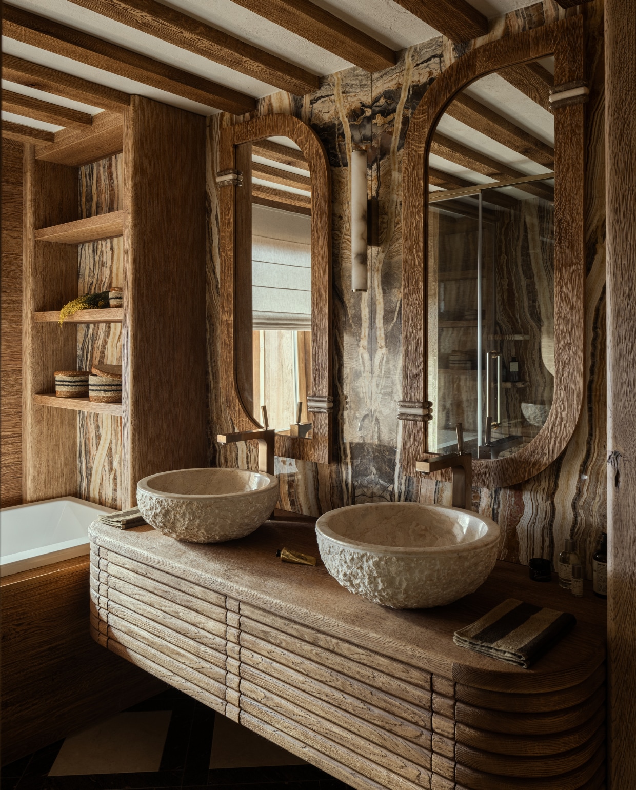Badkamer ontworpen door AS Interior Design. De wastafels zijn van ruw travertin, gevonden op een rommelmarkt. Wandlamp tussen de spiegels van NV Gallery. stijlvol wonen 08-2024 | Productie Living Inside | Fotografie Ramona Balaban