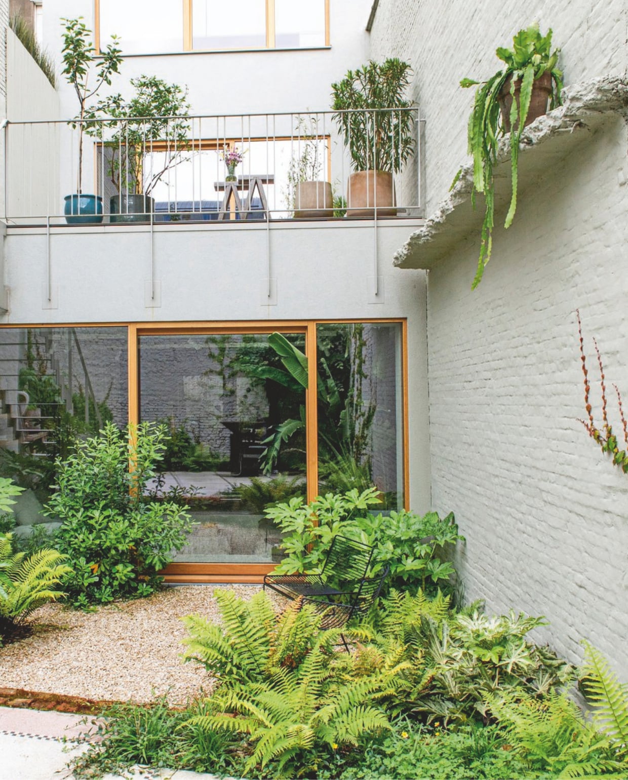 Plantenpotten D&amp;M Deco, de richel waar planten op staan is een restant van het plafond dat is weggesloopt. In de tuin vooral wintergroene planten zoals fatsia japonica’s en varens. vtwonen 13-2024 | styling Jeske Weel | fotografie Caroline Coehorst