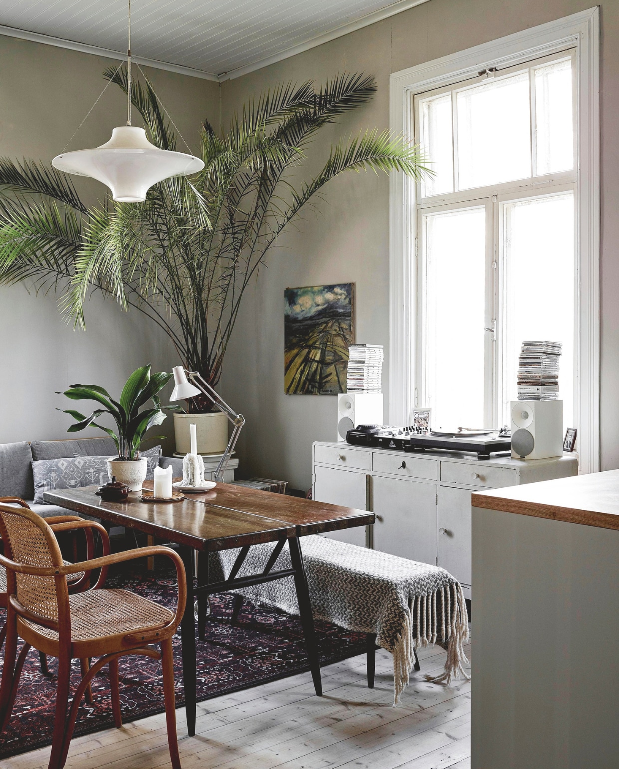 De meer dan honderd jaar oude vloer kwam onder vele andere vloeren vandaan. Tafel, eetkamerbank en stoelen vlooienmarkt. Hanglamp Lokki Nordic Nest. vtwonen 13-2024 | productie jonna kivilahti | fotografie krista keltanen