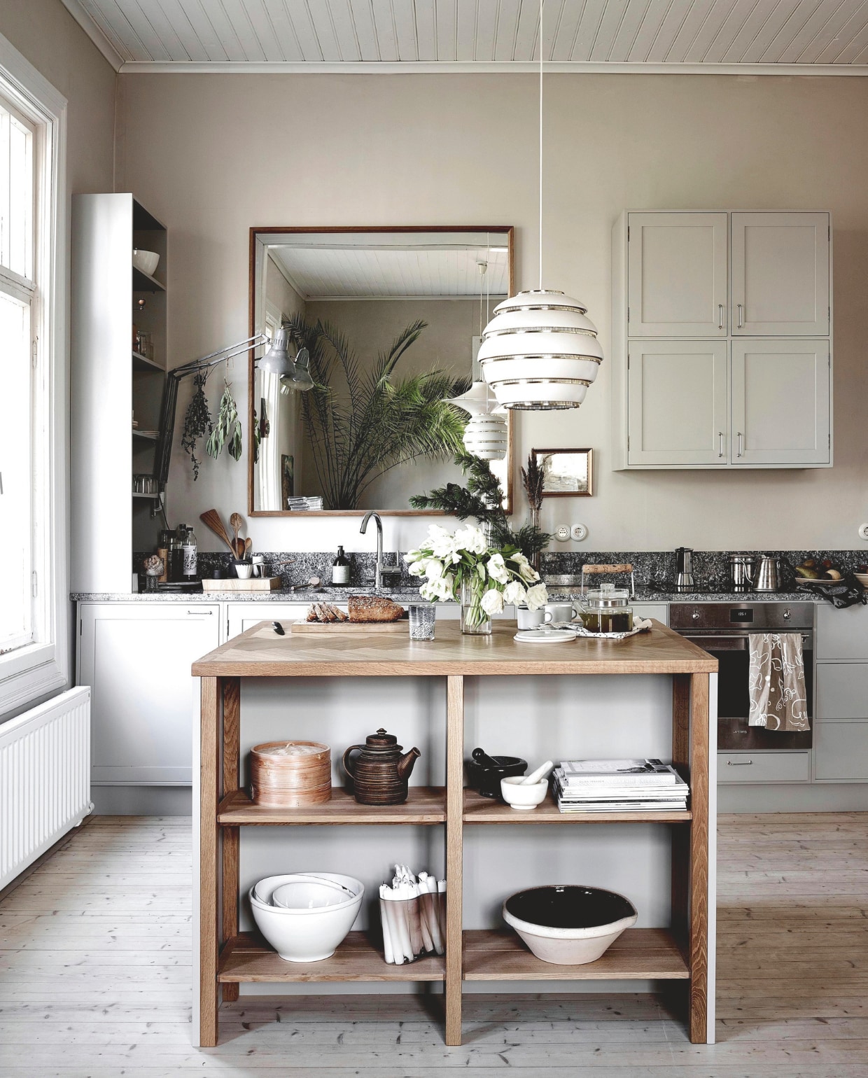 Keuken maatwerk. Hanglamp Artek. Vergelijkbare spiegel Maisons du Monde. vtwonen 13-2024 | productie Jonna Kivilahti | fotografie Krista Keltanen