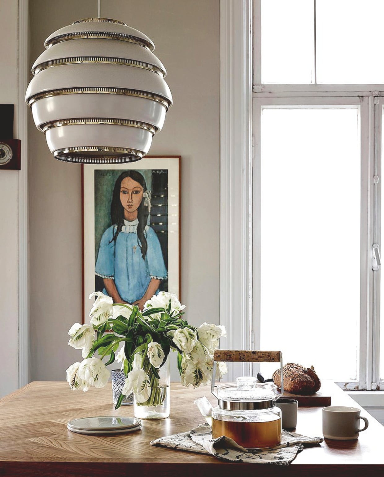Reproductie van Amedeo Modigliani vlooienmarkt. Hanglamp Artek. Keukeneiland maatwerk. vtwonen 13-2024 | productie Jonna Kivilahti | fotografie Krista Keltanen