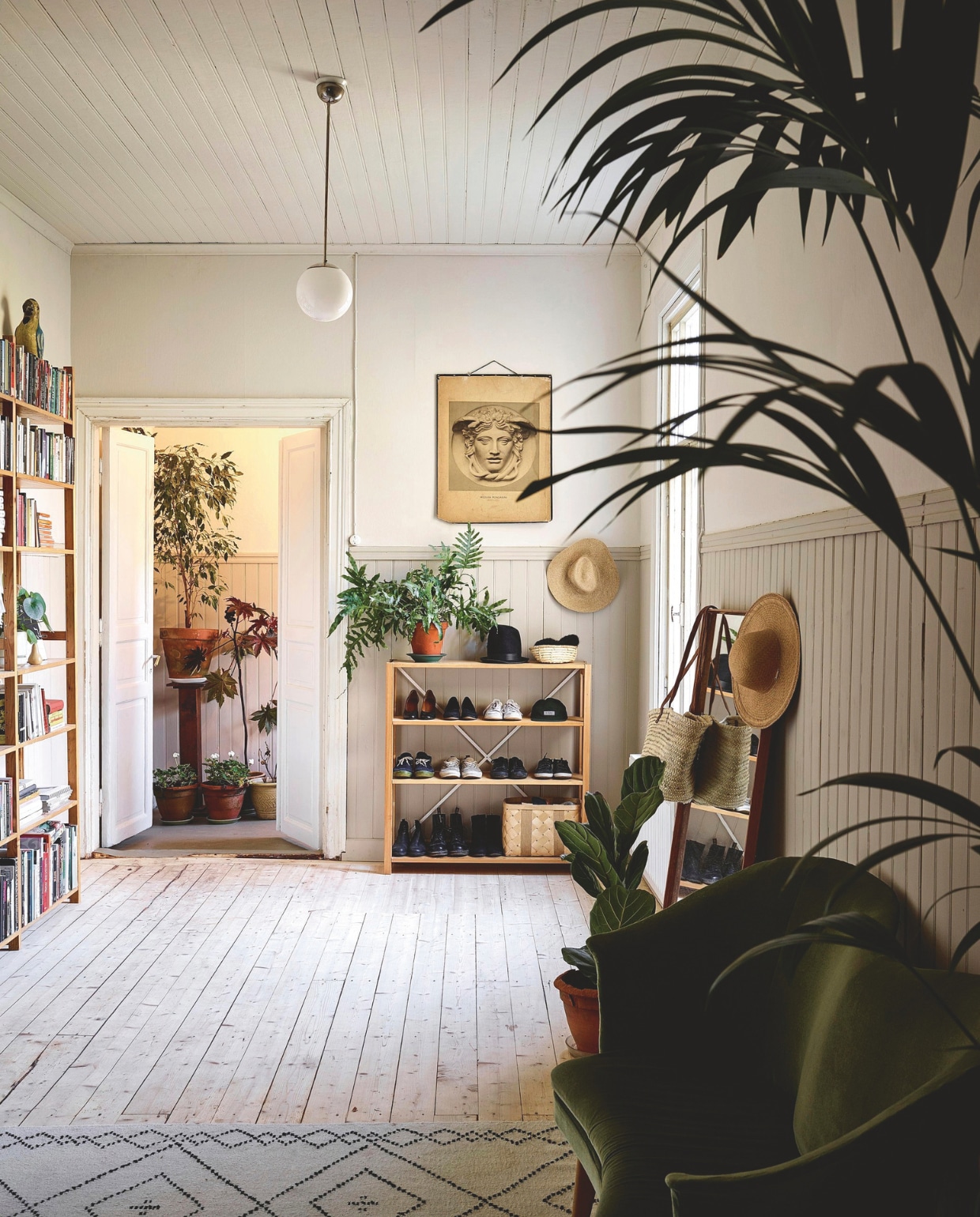 De meer dan honderd jaar oude vloer was nog prima. Vloerkleed eigen ontwerp. Boekenkast Lundia. Spiegel vlooienmarkt. vtwonen 13-2024 | productie Jonna Kivilahti | fotografie Krista Keltanen