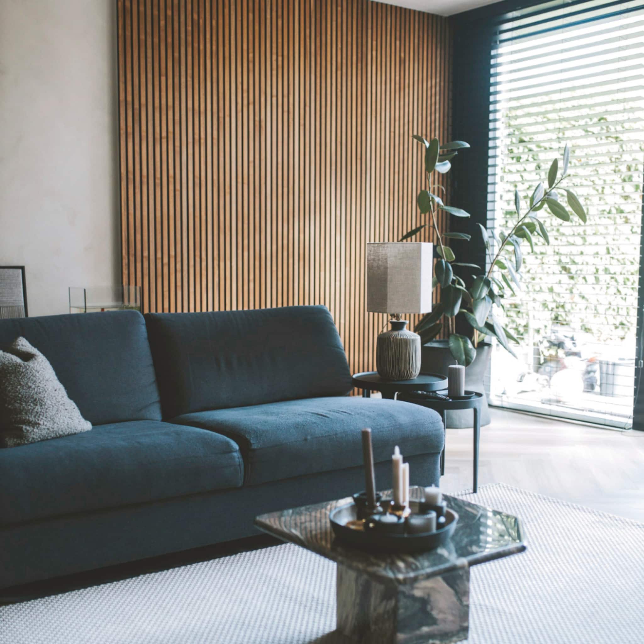 Minimalistische woonkamer met een blauwe bank en houten panelen
