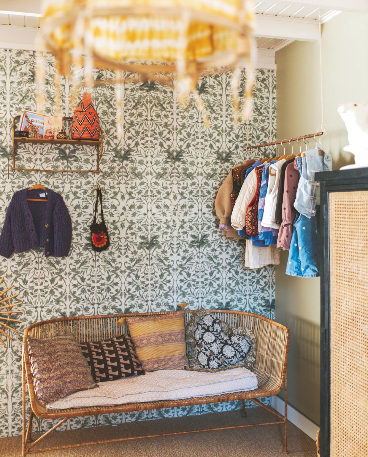 Rotan bank House Doctor. Behang Creative Lab Amsterdam. Kledingrek zelfgemaakt van koperen buis. Hanglamp Laif en Nuver. Mand Club Nomad. Kussens Doing Goods en HKliving. Sisal vloer Carpetright. vtwonen binnenkijkspecial 11-2024 | fotografie Merel Visscher, Beate vieth