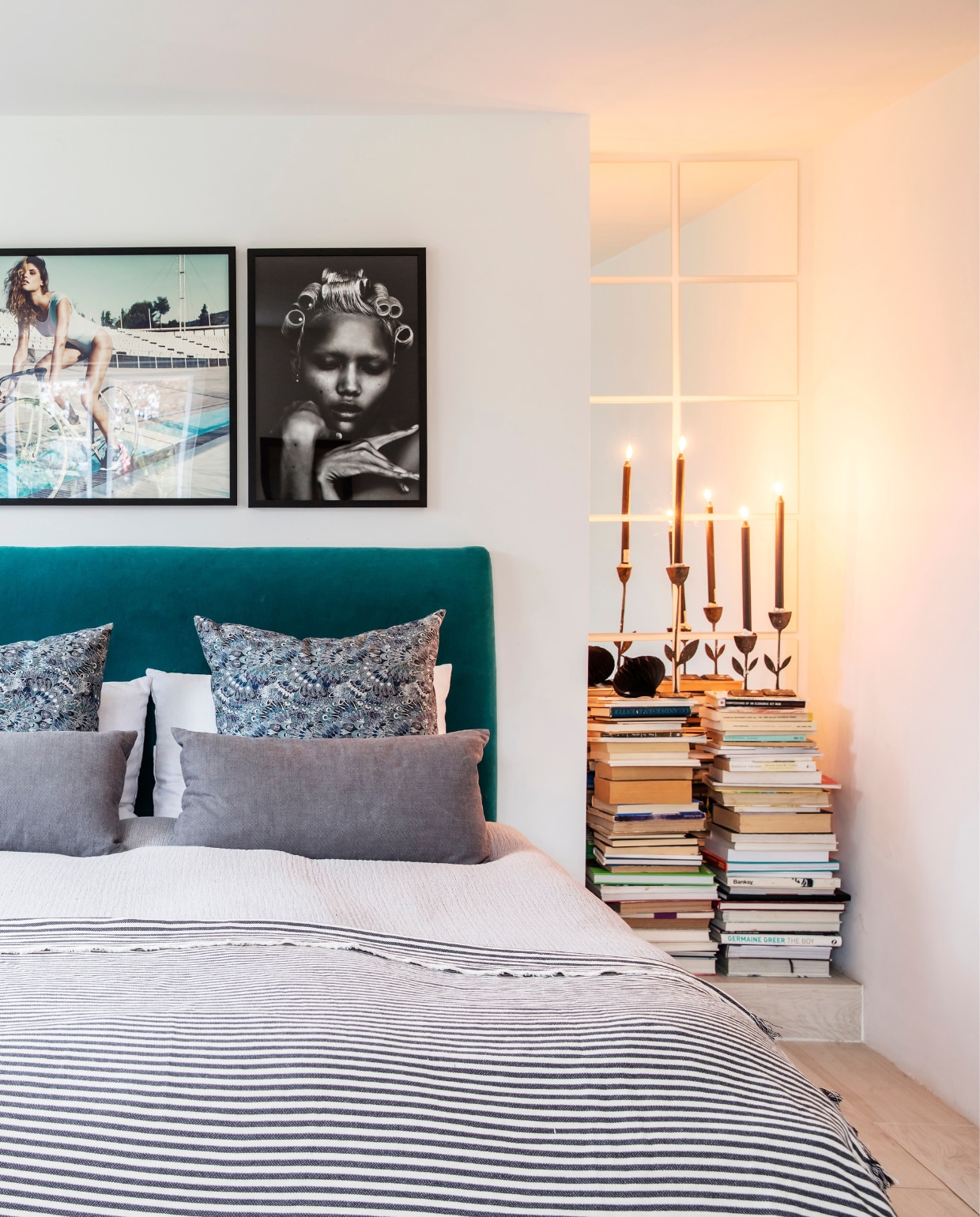 Beddengoed en kussens van Ikea en Tine K Home. Kandelaars vintage. Zwarte tafellamp Tine K Home.Bijzettafel Gubi. Fotokunst The Wall Market. Overig herkomst onbekend. vtwonen 12-2021 | productie LivingInside | styling Rikke Graff Juel | fotografie Christina Kayser O