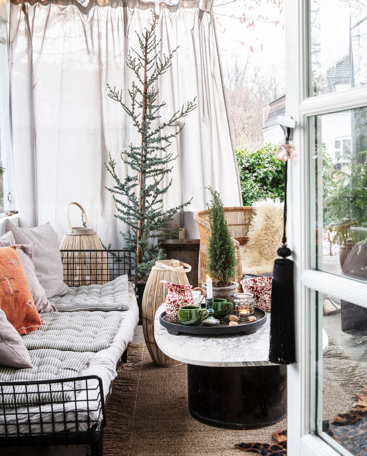 Bank en bijzettafel vintage. Kussens en spreien van Ikea, Tine K Home en uit Marokko.Stoel Tine K Home. Bamboe lantaarns Broste Copenhagen. Overig herkomst onbekend. vtwonen 12-2021 | productie LivingInside | styling Rikke Graff Juel | fotografie Christina Kayser O