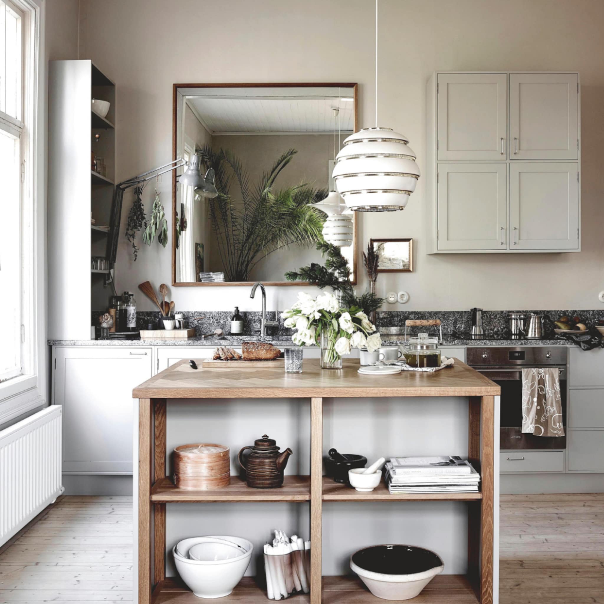 Naturel keuken met een marmeren werkblad en een kookeiland vol keukengerei