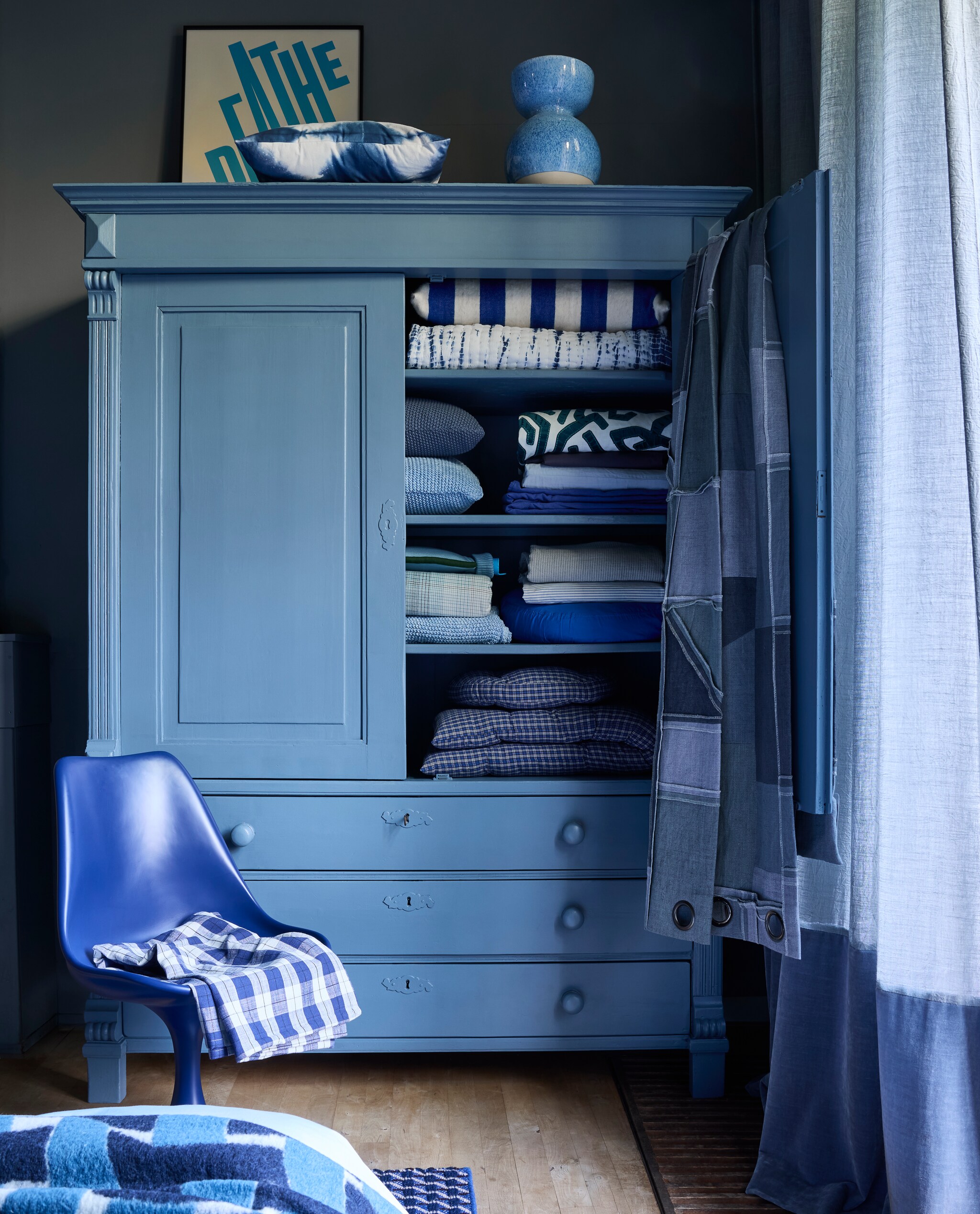 Krijtverf Blue Stone, 1 liter € 51,45 (pure-original.com). Houten kast, maatwerk, prijs op aanvraag (com-anders.nl). Gordijnstof Tick-Tock Crushed Reboot van Chivasso, linnen en polyester, 300 cm (h) per meter € 147,50 met gordijnstof Sensual Velvet van Chivasso, polyester en katoen, 140 cm (b) per meter € 105,- (jab.de). Keramische vaas Bol, vanaf € 40,- (polspotten.com). Polyester stoel Tulip van Household Hardware, 49x45x83 cm (bxdxh) € 495,- en kussen Tie-Dye (op kast) € 34,95 (shop.vtwonen.nl). Randje van poster Breathe van Paper Collective, vanaf € 40,- met aluminium lijst Alpha, vanaf € 49,95 (loods5.nl). Patchwork stof Reclaim Reversible Denim van Kirkby Design, katoen en linnen, 140 cm, per meter € 254,50 (romo.com). In de kast, van boven naar beneden: blauw-wit gestreept wollen kussen Household Hardware € 95,- en gewatteerde plaid Tie-Dye van vtwonen € 99,95 (shop.vtwonen.nl). Biologisch katoenen kussens Nordic Knit van Marc O’Polo € 69,95 (essenzahome.nl). Blauw-wit geappliceerde stof Arp Cerulean van Zinc Textile, 136 cm, per meter € 261,- (romo.com). Donkerblauw linnen dekbedovertrek € 149,95 (suitse702.com). Lichtblauw katoensatijnen hoeslaken Minte van Essenza Home € 64,95 (essenzahome.nl). Kobaltblauw katoenen beddengoed € 117,45 en warmwaterkruik Bumper, natuurlijk rubber en biologisch katoen € 49,96 (suitse702.com). Geruit katoenflanellen dekbed-overtrekset Phia van Marc O’Polo € 119,95, biologisch katoenen plaid Nordic Knit van Marc O’Polo € 129,95 (essenzahome.nl). Fijngestreepte linnen stof Spring Vintage Blue van Kirkby Design, 260 cm, per meter € 178,- (romo.com). Biologisch katoensatijnen dekbedovertrekset Janne € 99,95 (essenzahome.nl). Op stoel: geruit katoenen tafelkleed van Madam Stoltz 65,60 (deens.nl). vtwonen 4-2025 | styling Marianne Luning | fotografie Alexander van Berge