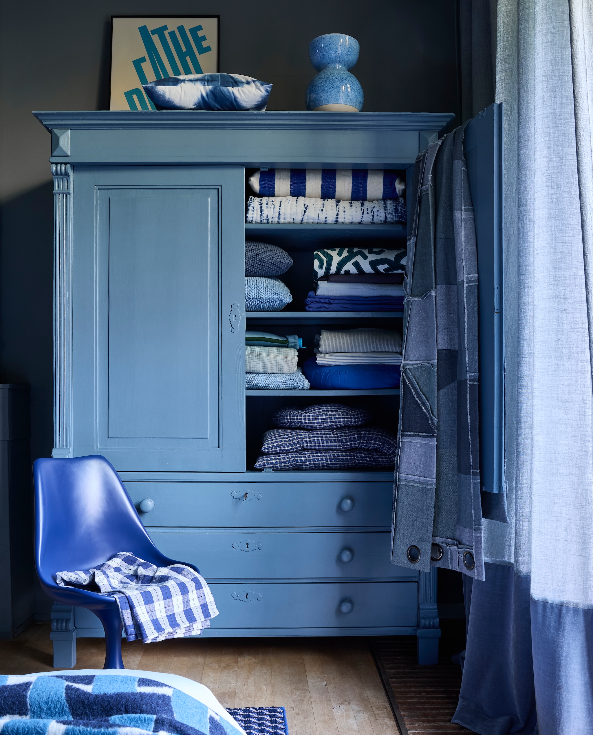 Krijtverf Blue Stone, 1 liter € 51,45 (pure-original.com). Houten kast, maatwerk, prijs op aanvraag (com-anders.nl). Gordijnstof Tick-Tock Crushed Reboot van Chivasso, linnen en polyester, 300 cm (h) per meter € 147,50 met gordijnstof Sensual Velvet van Chivasso, polyester en katoen, 140 cm (b) per meter € 105,- (jab.de). Keramische vaas Bol, vanaf € 40,- (polspotten.com). Polyester stoel Tulip van Household Hardware, 49x45x83 cm (bxdxh) € 495,- en kussen Tie-Dye (op kast) € 34,95 (shop.vtwonen.nl). Randje van poster Breathe van Paper Collective, vanaf € 40,- met aluminium lijst Alpha, vanaf € 49,95 (loods5.nl). Patchwork stof Reclaim Reversible Denim van Kirkby Design, katoen en linnen, 140 cm, per meter € 254,50 (romo.com). In de kast, van boven naar beneden: blauw-wit gestreept wollen kussen Household Hardware € 95,- en gewatteerde plaid Tie-Dye van vtwonen € 99,95 (shop.vtwonen.nl). Biologisch katoenen kussens Nordic Knit van Marc O’Polo € 69,95 (essenzahome.nl). Blauw-wit geappliceerde stof Arp Cerulean van Zinc Textile, 136 cm, per meter € 261,- (romo.com). Donkerblauw linnen dekbedovertrek € 149,95 (suitse702.com). Lichtblauw katoensatijnen hoeslaken Minte van Essenza Home € 64,95 (essenzahome.nl). Kobaltblauw katoenen beddengoed € 117,45 en warmwaterkruik Bumper, natuurlijk rubber en biologisch katoen € 49,96 (suitse702.com). Geruit katoenflanellen dekbed-overtrekset Phia van Marc O’Polo € 119,95, biologisch katoenen plaid Nordic Knit van Marc O’Polo € 129,95 (essenzahome.nl). Fijngestreepte linnen stof Spring Vintage Blue van Kirkby Design, 260 cm, per meter € 178,- (romo.com). Biologisch katoensatijnen dekbedovertrekset Janne € 99,95 (essenzahome.nl). Op stoel: geruit katoenen tafelkleed van Madam Stoltz 65,60 (deens.nl). vtwonen 4-2025 | styling Marianne Luning | fotografie Alexander van Berge