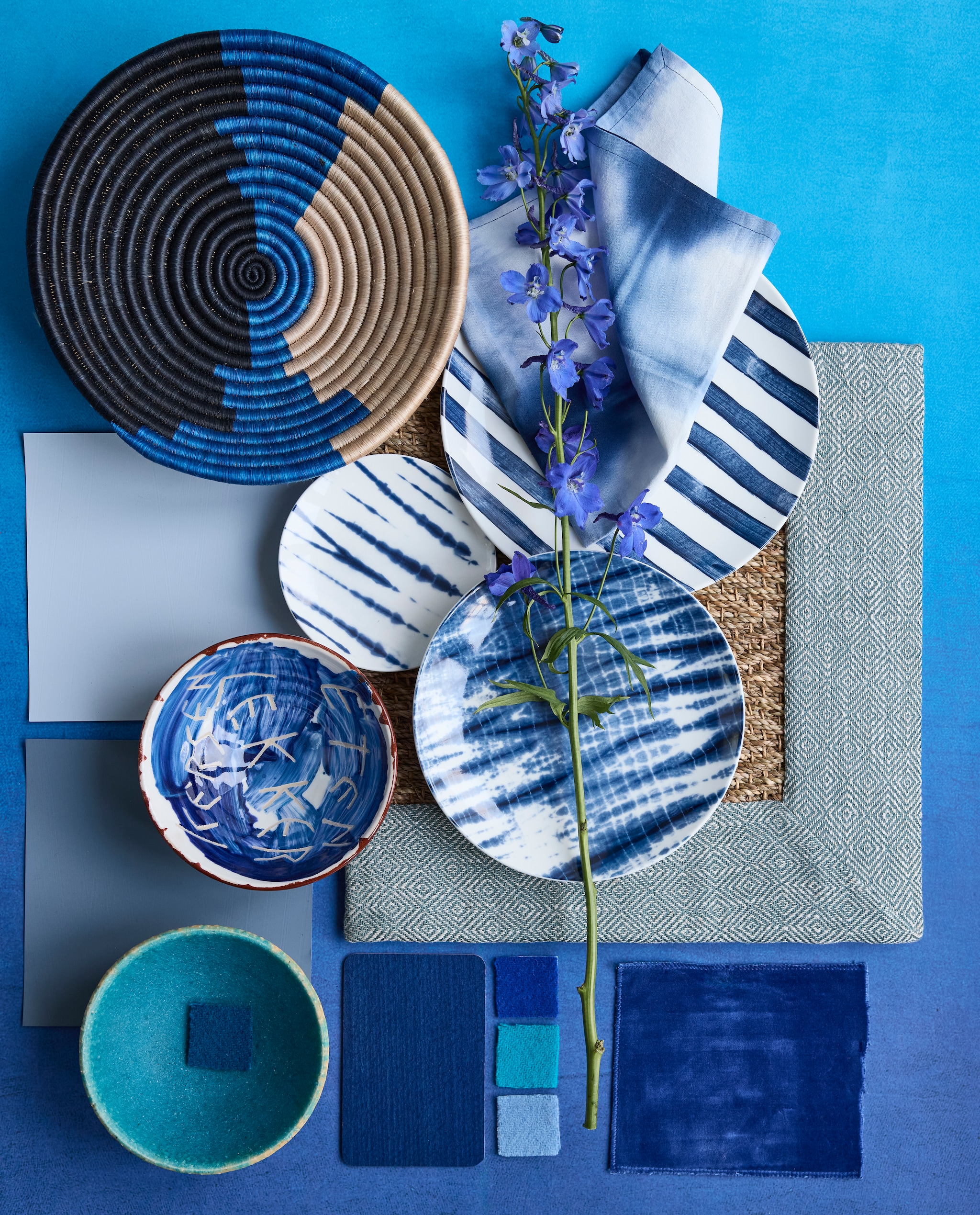 Aquablauw bord en schaal met letters Unica van Polspotten x Norman Trapman € 45 (polspotten.com). Porseleinen borden Tie-Dye van vtwonen, vanaf € 5,95, katoenen servet Tie-Dye van vtwonen, set van 2 € 12,95 en sisal wandschaal Shoreline van Maison Suku € 34,95 (shop.vtwonen.nl). Stalen: behang Saraille Cobalt van Designers Guild, 300x45 cm (lxb) per rol € 449,- (wva.nl). Zeegras vloerkleed met gerecycled katoenen randafwerking, prijs op aanvraag (cunera.nl). Wollen stalen van plaids (aabe.nl). Kalkverf Blue Bay, 1 liter € 66,- en binnenlak Denim van Lab Paint, 500 ml € 51,- (vestingh.nl). vtwonen 4-2025 | styling Marianne Luning | fotografie Alexander van Berge