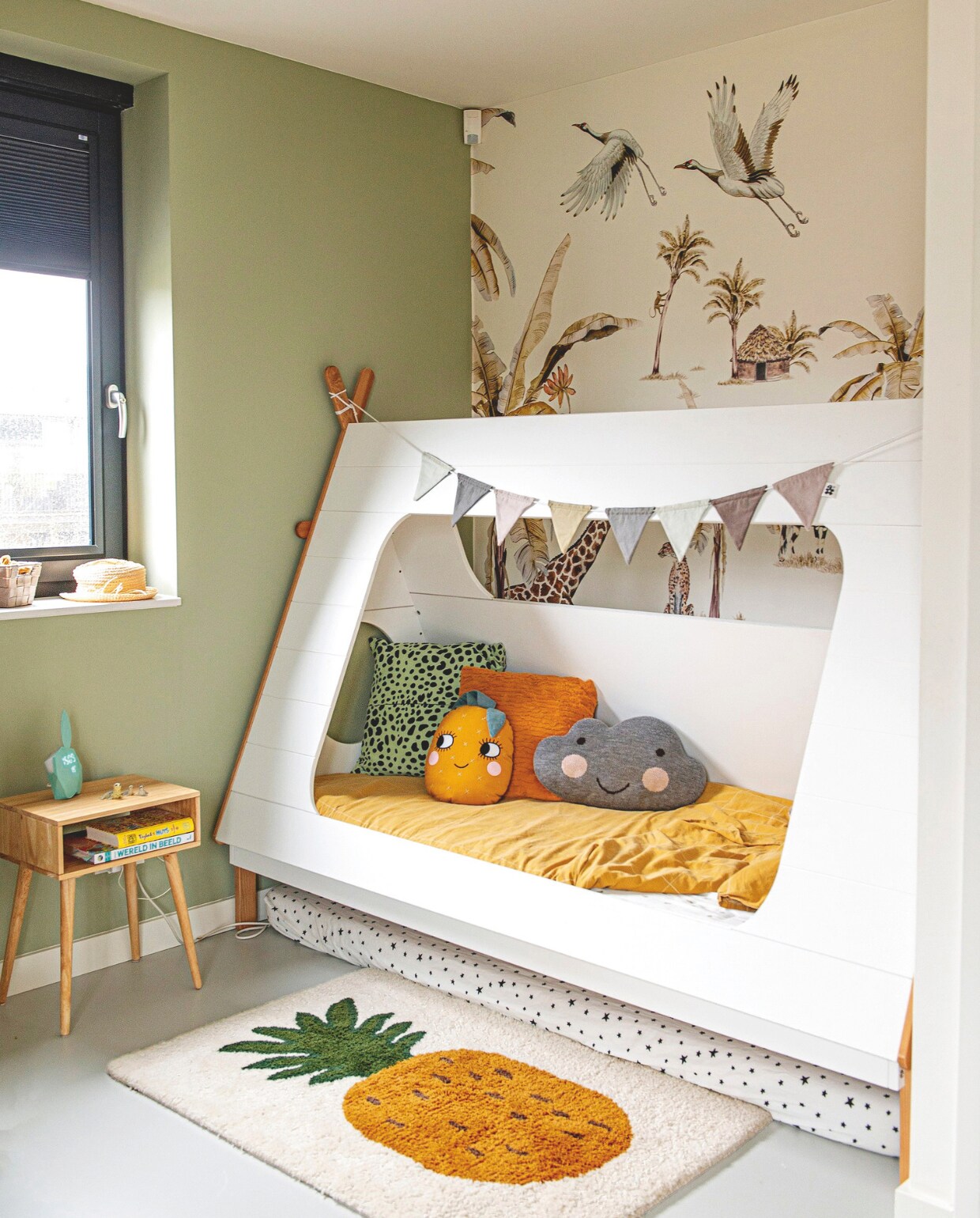 Bed Woood. Kussens: groene dierenprint Sissy-Boy Homeland, ananas Roommate, okergeel Intratuin, wolk cadeau. Ananaskleed Ferm Living. Nachtkastje Loods 5. Vlaggenslinger Sebra. Behang Creative Lab Amsterdam. Muurverf Vert De Terre van Farrow &amp; Ball. vtwonen binnenkijkspecial 11-2024 | styling Jeske Weel | fotografie Caroline Coehorst