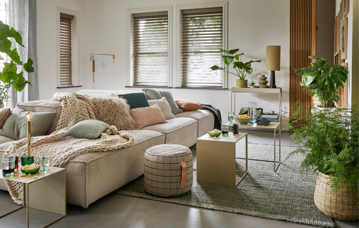 Ecru elementenbank Square van Easy Sofa, per module vanaf € 605,- (hoekbankxxl.nl). Groen geweven vloerkleed Versanti van Linie Design, 240x170 cm € 440,- (vtwonen.nl). Ecru metalen bijzettafel Cluster van Ferm Living, set van 3 € 380,-, grijze geruite poef Grid van Oyoy, 40x38 cm (Øxh) € 104,55, groene kristalglazen kandelaar Parker, 8x3x8 cm € 24,65 (wonenmetlef.nl). Crèmekleurige gebreide plaid, 152x127 cm € 149,- (noirhome.nl). Kussens van links naar rechts: lichtbruin kussen met visgraatmotief Kata van Oyoy, 40x60 cm € 57,80 (wonenmetlef.nl), linnen kussen Olive, 40x60 cm € 59,- (bymolle.com), kussen Nordic Knit van Marc O’Polo, 30x60 cm € 39,99 (vtwonen.nl), schapenvachtkussen, 40x40 cm € 69,- (noirhome.nl), groen gebreid kussen Solid van Malagoon, 50x50 cm € 49,99 (vtwonen.nl), linnen kussen Blush, 35x50 cm € 49,-, gerecycled gebreid denim kussen Sand, 40x60 cm € 79,-, linnen kussen Olive, 60x60 cm € 69,-, linnen kussen Cinnamon, 40x60 cm € 59,- (bymolle.com). Donkergroene merinowollen deken van McNutt, 200x145 cm € 100,-, groen glas van Serax, medium € 9,50, groene glazen popcornschaaltjes Emeralds, 12,5 cm (Ø), per stuk € 12,10, groen aardewerken chipsschaaltje Miscellaneous € 7,- (vanmanenaantafel.nl). Gerecycled wijnglas Oli van Ferm Living € 25,-, gerecyclede glazen karaf Oli Jug van Ferm Living € 39,-, groene kaars Dryp van Ferm Living, per 2 € 11,-, metalen plantenbak op poten Two Tier van Ferm Living, 25x75x80 cm € 299,-, fotolijsten aan rechter wand, vanaf € 35,- (byjensen.nl). Plant Philodendron, groot € 149,95, bamboe mand € 200,-, op side table plant Philodendron € 22,50, groene metalen pot € 35,-, plant rechts Monstera € 28,95, plant voor Asparagus € 44,95, bamboe mand € 89,- (stadstuindebloemenpoort.nl). Messing wandlamp Swing van House Doctor, 65x35 cm € 199,-, mosgroene keramieken vaas Eminent Circles, medium € 49,99, keramieken tafellamp Stoneware met lampenkap van HKliving € 209,-(vtwonen.nl). Terracotta bloempot Rosa, 12 cm (Ø ) € 9,50 (bymolle.com). Lichtbruin aardewerken suikerschaaltje Hagi van Oyoy (wonenmetlef.nl). Overig privébezit. vtwonen 02-2023 | styling Femke Pastijn | fotografie Peggy Janssen