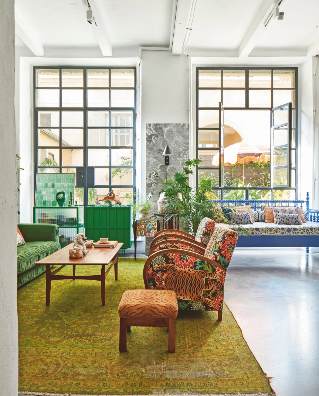 Perzisch tapijt, salontafel, poef, plantentafels vintage. Vintage stoelen bekleed met stof van Gastón y Daniela. Daybed, kleine kussens op het daybed, het beklede daybedmatras en accessoires op groene kasten Nap Atelier. Bank, groen dressoir, dressoir met geribbeld glas, effen en gestreepte kussens op het daybed en groen accessoire HKliving. Wandlamp House Doctor. vtwonen 09-2024 | styling Francesca Davoli | fotografie Fabrizio Cicconi