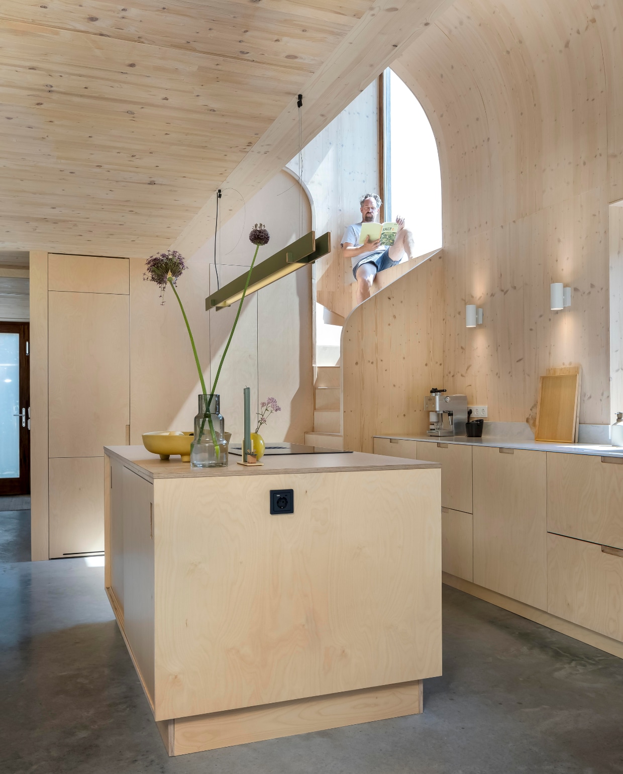 De rondingen in het trapgat volgen die van het plafond. Dankzij de dikte van de gevelconstructie waren er diepe vensterbanken mogelijk. Veel tussenwanden hebben ingebouwde kasten. Hele interieur inclusief keuken Wel Interieurs, werkblad Himacs Aurora Grey van Baars & Bloemhoff. Schaal Loods 5, geel vaasje Des Pots, grote vaas cadeau, kandelaar Floris Hovers, hanglamp Tube van Kilo, witte spots Ikea, zwart stopcontact Berker Q1, gietvloer van gevlinderd beton. vtwonen 01-2025 | fotografie Hennie van Belkom | tekst Christine van der Hoff