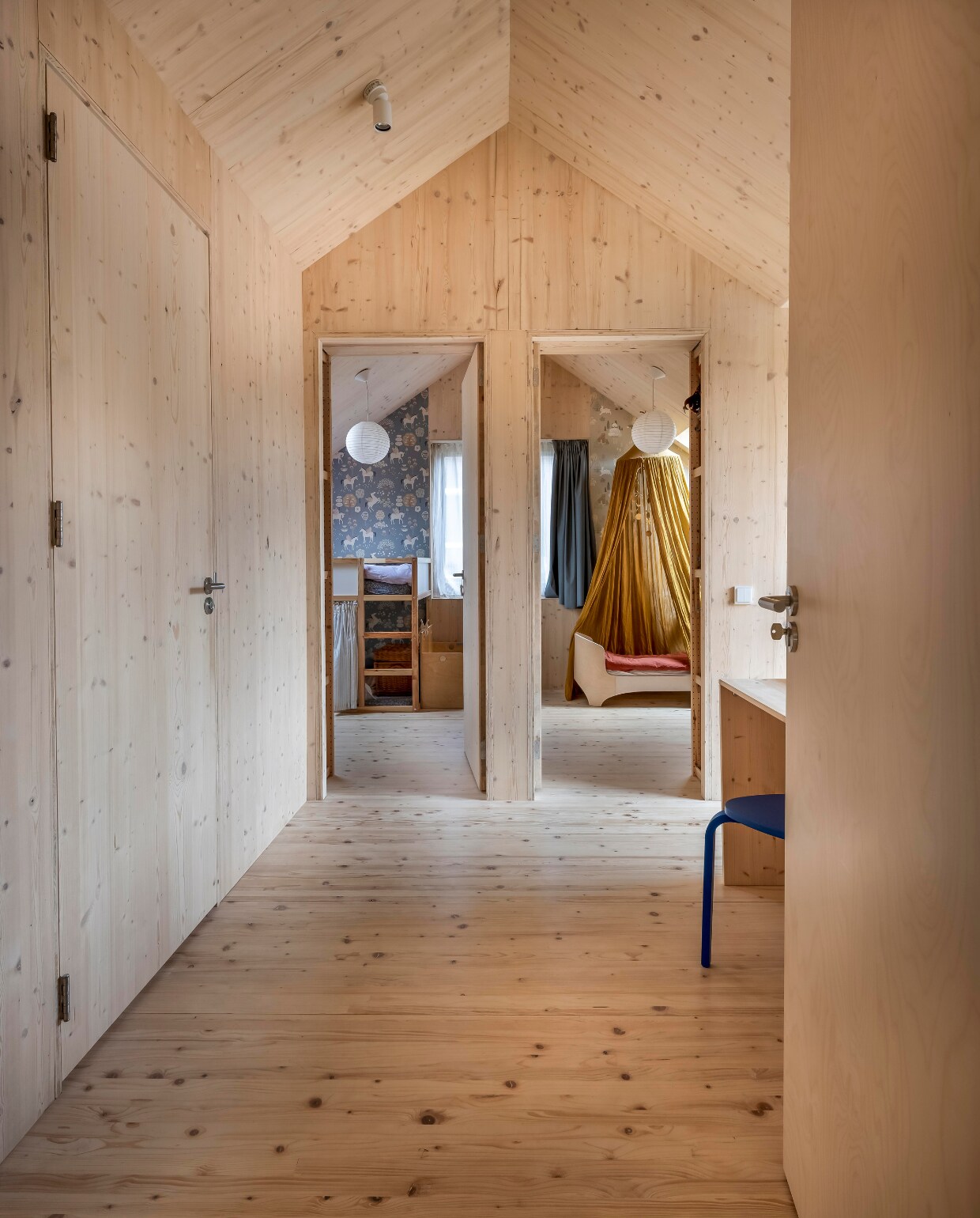 De slaapkamers van de meisjes worden gescheiden door een schuifwand, zodat er overdag meer speelruimte is. Behang Majvillan, hoogslaper Ikea, papieren lampen Bol,hemel Sebra, ledikant Leander, rood beddengoed Wehkamp. vtwonen 01-2025 | fotografie Hennie van Belkom