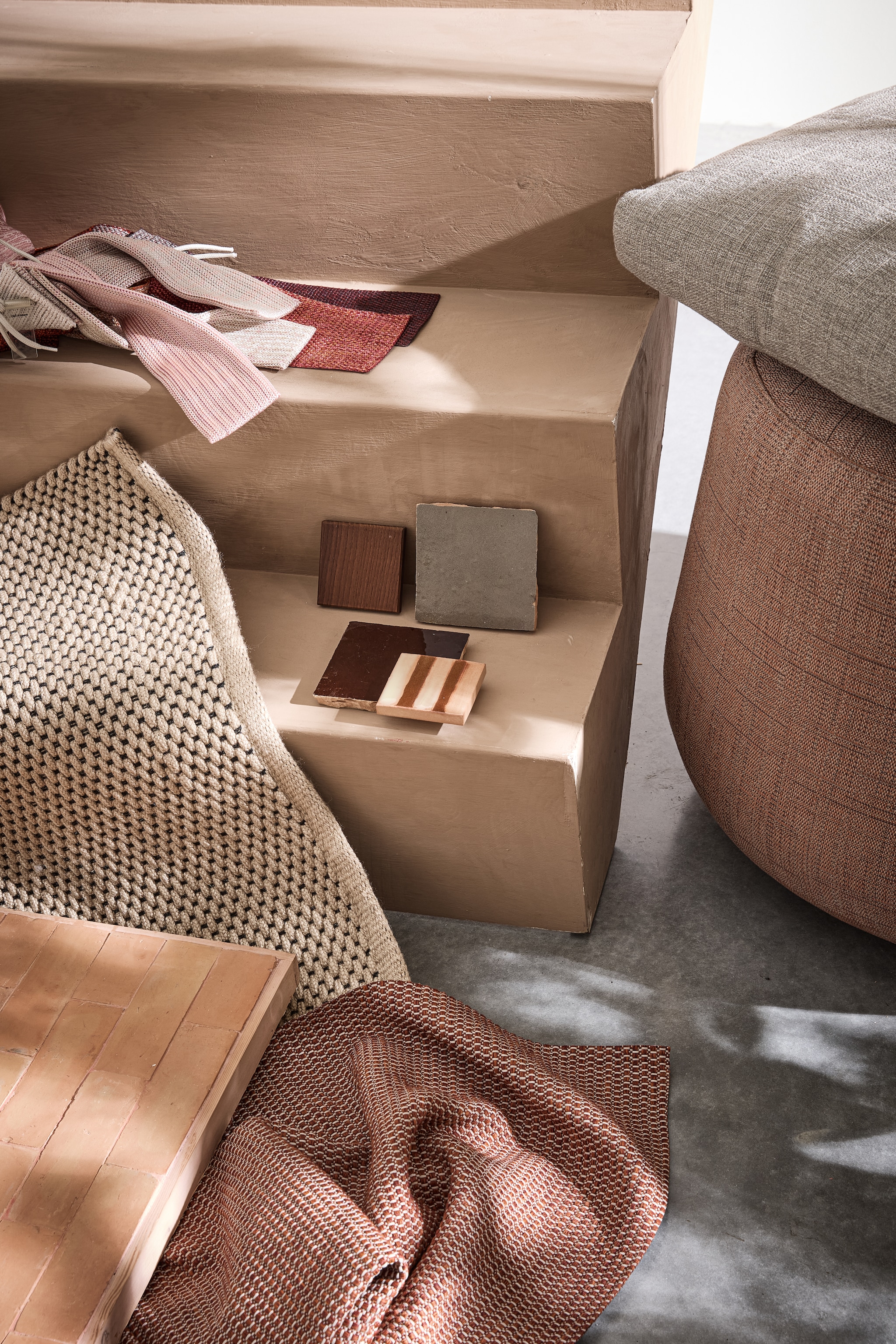 Vloerkleed Brink &amp; Campman, prijs op aanvraag (vloerkledenwinkel.nl). Polyolefine stofstalenset Chain outdoor en Rope, houten staal  Aurea Le232 en gestreepte tegel Segni Pml126 van Paola Lenti, terracotta stofstaal, kussen en poef Fat-Sofa Outdoor van B&amp;B Italia vanaf € 884,- (dacks.nl). Terracotta tegels met roze voegsel en grijze en bruine tegels Zelliges, per m² € 115,- (householdhardware.nl). styling marlies does | fotografie peggy janssen