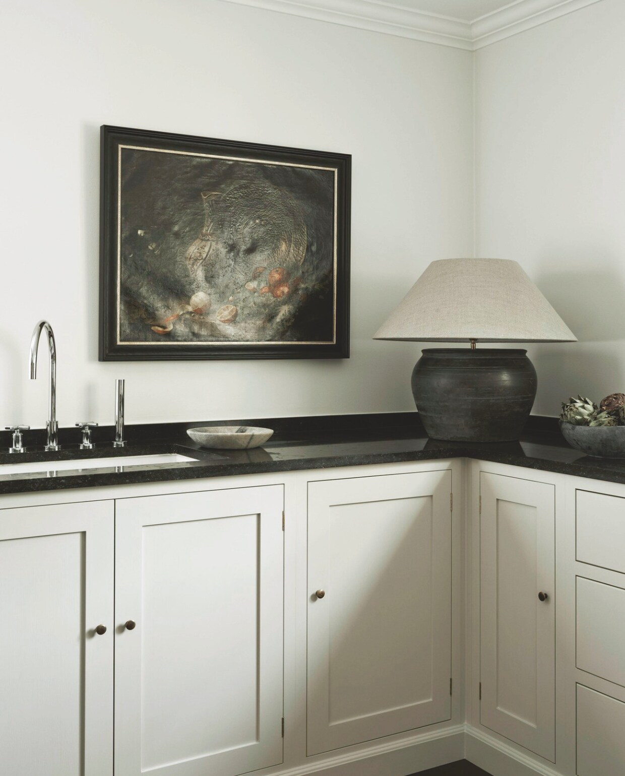 Keuken van het Engelse DeVol Kitchens. Kraan Dornbracht. Tafellamp vintage. Geschilderd stilleven antiek. vtwonen landelijk 08-2024 | Productie Living Inside | Fotografie Kristofer Johnsson