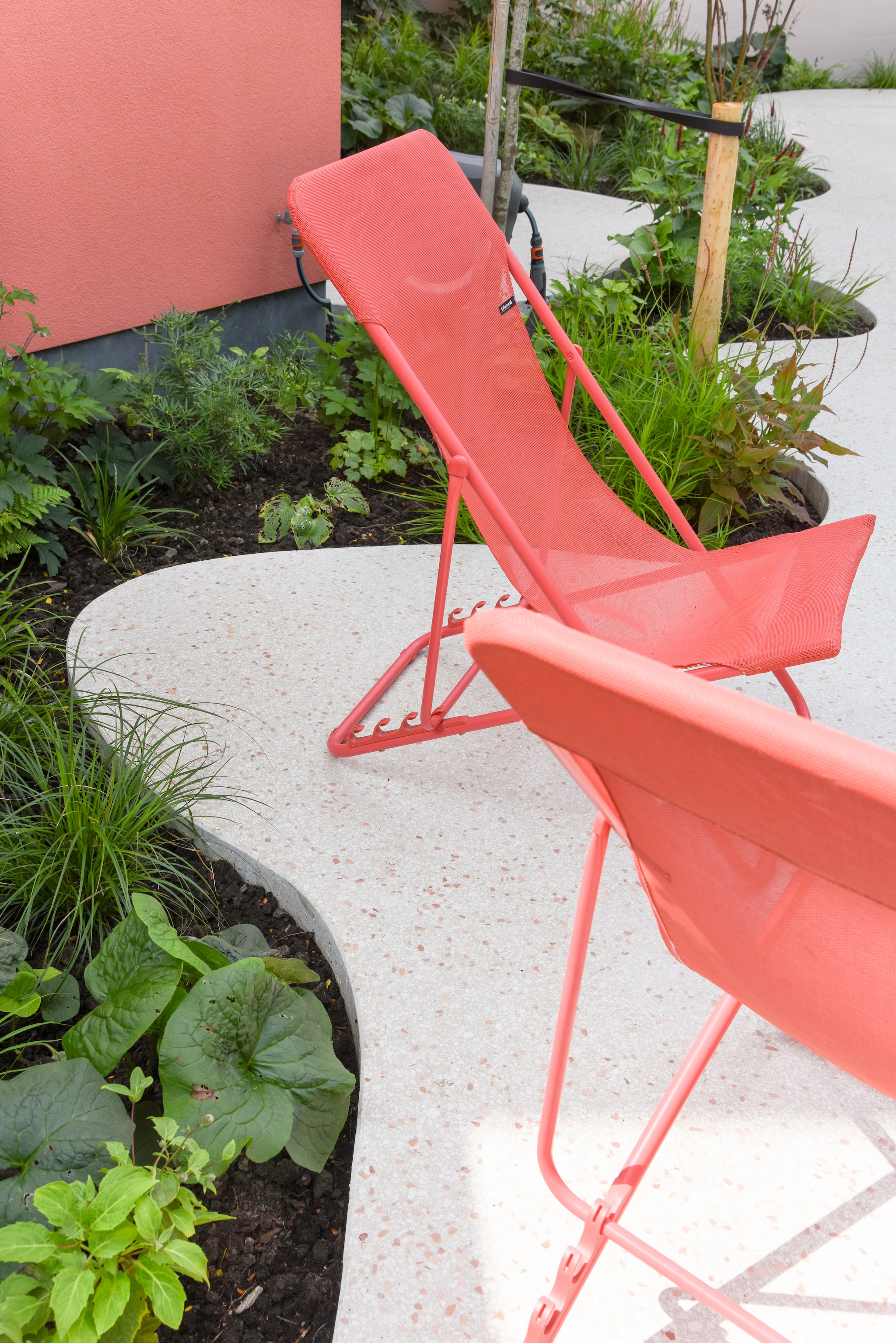 De roze stoelen kochten Lynn en Aaron tweedehands en zijn van Lafuma. vtwonen TUIN 01-2025 | fotografie Veronique De Walsche