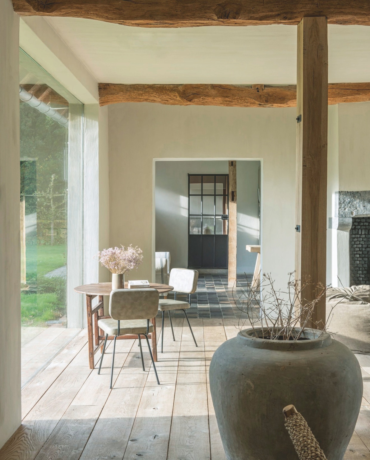 Koffietafel en grote kruik antiek. Planken vloer en steunpilaren van eikenhout. vtwonen landelijk 01-2025 | styling Marc Heldens | fotografie Verne Photography