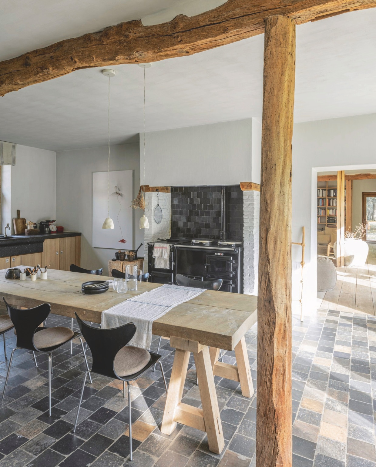 Eettafel van massief eikenhout Moka Tales. Vintage stoelen Arne Jacobsen. De originele tegelvloer werd hersteld. vtwonen landelijk 01-2025 | styling Marc Heldens | fotografie Verne Photography