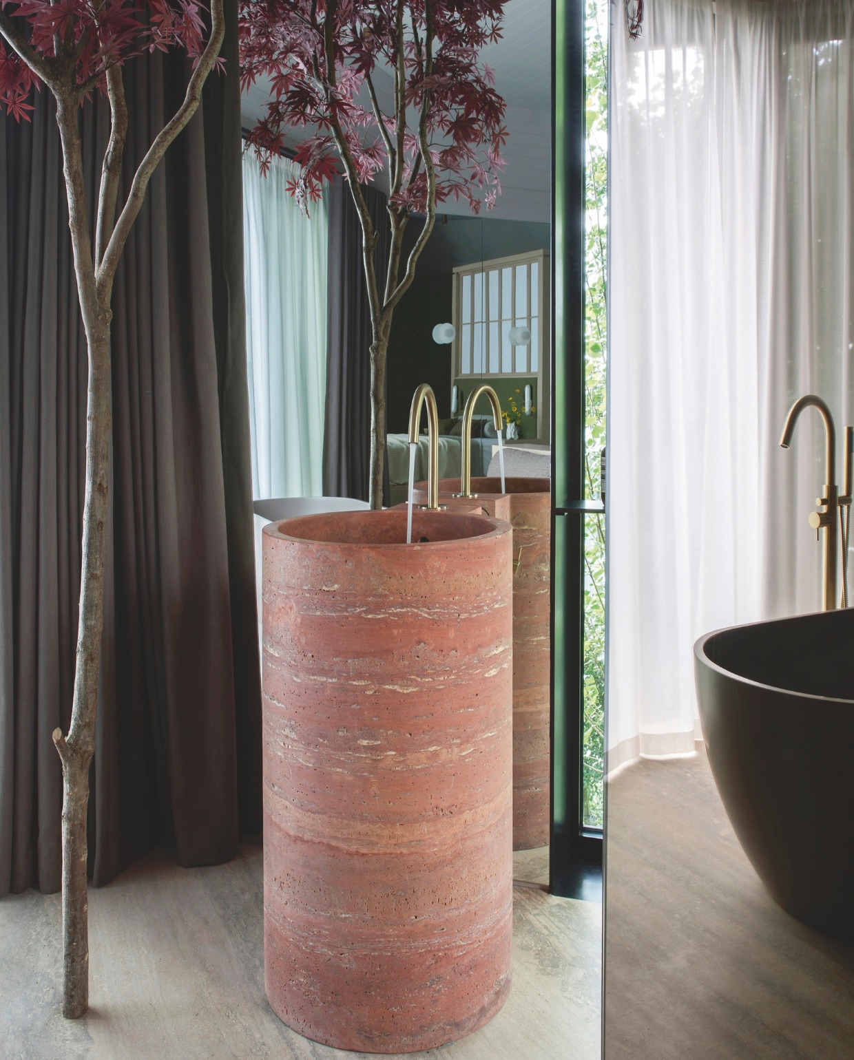 Blikvanger in de suite is de vrijstaande rode travertin wastafel, speciaal voor dit project op maat gemaakt. Stijlvol Wonen 01-2025 | productie Living Inside | fotografie Ruth Maria Murphy