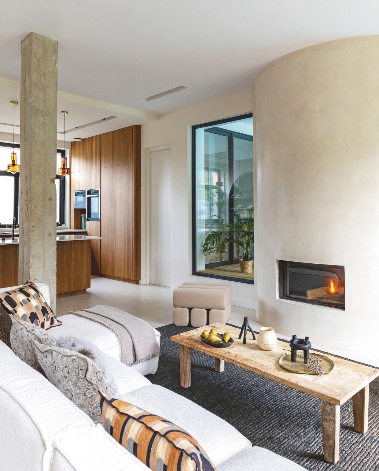 De afgeronde open haard is een ontwerp van Anna in samenwerking met Kalfire. Stijlvol Wonen 01-2025 | styling Marie-Maud Levron | fotografie Cecile Perrinet-Lhermitte | productie en brontekst AC Scoffoni | tekstbewerking Anneleen Peeters