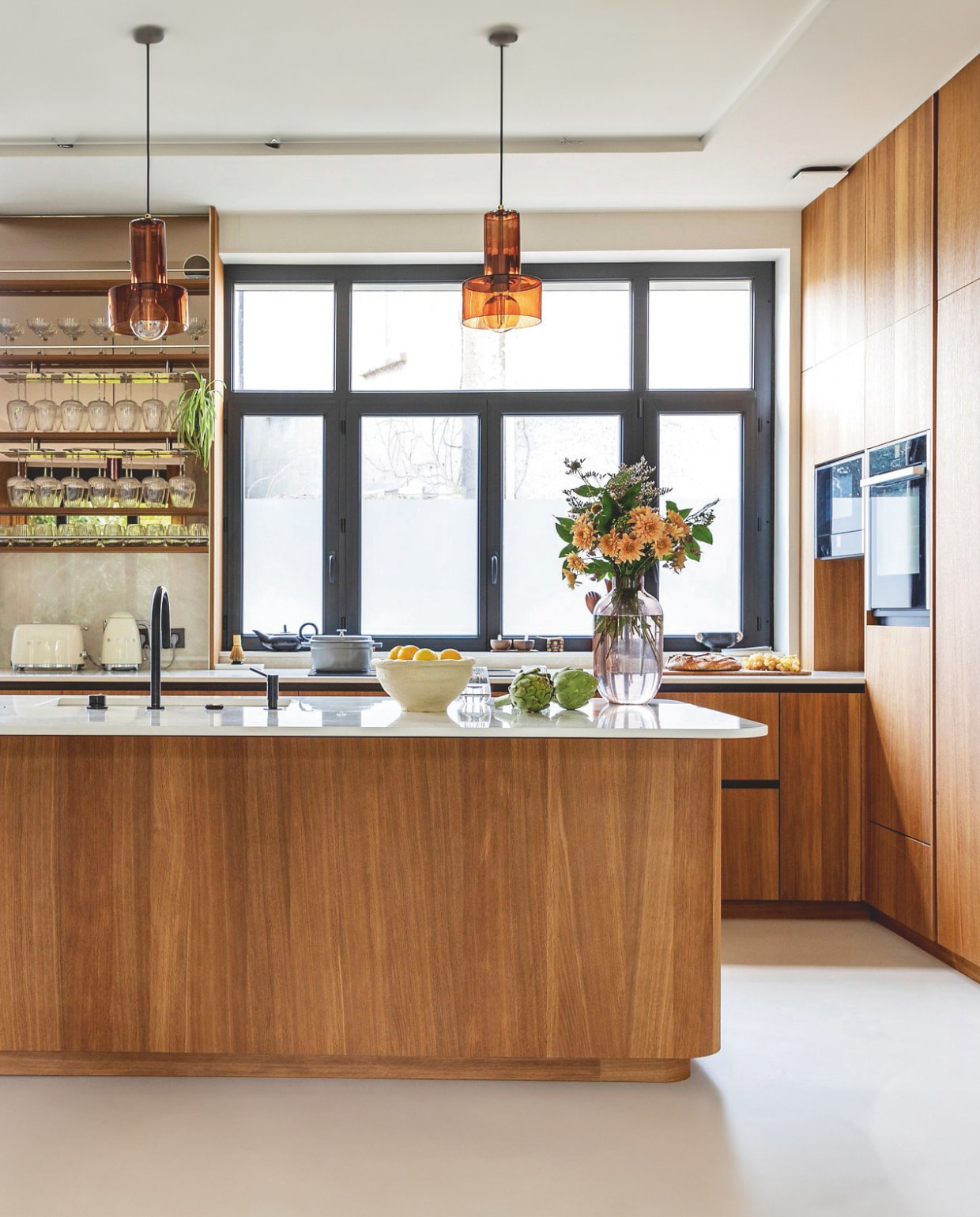 De keuken is een ontwerp van Anna in samenwerking met Veneta Cucine. De fronten zijn van gebeitst eiken. Plafondlampen Westwing. Oven Neff, kraan Bradano. Stijlvol Wonen 01-2025 | styling Marie-Maud Levron | fotografie Cecile Perrinet-Lhermitte | productie en brontekst AC Scoffoni