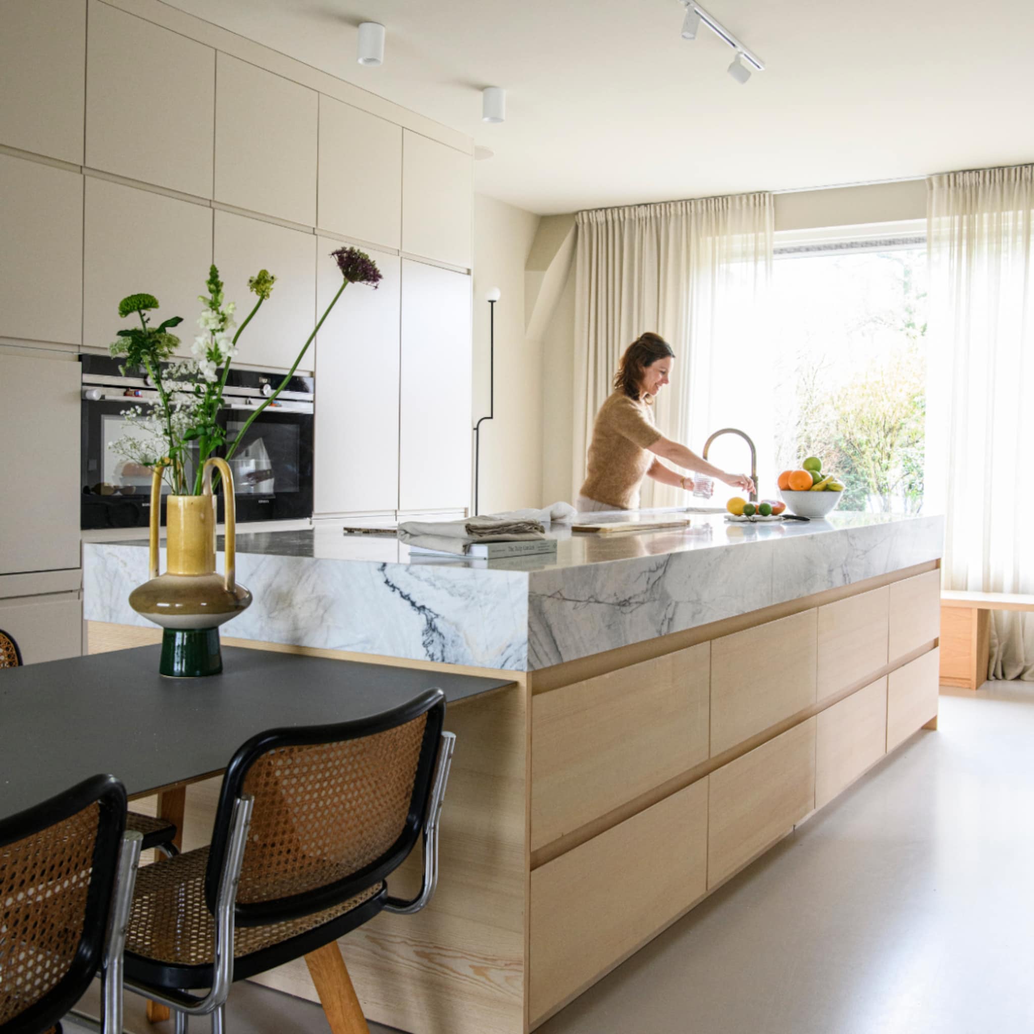 Scandinavische keuken met een kookeiland en marmeren aanrechtblad