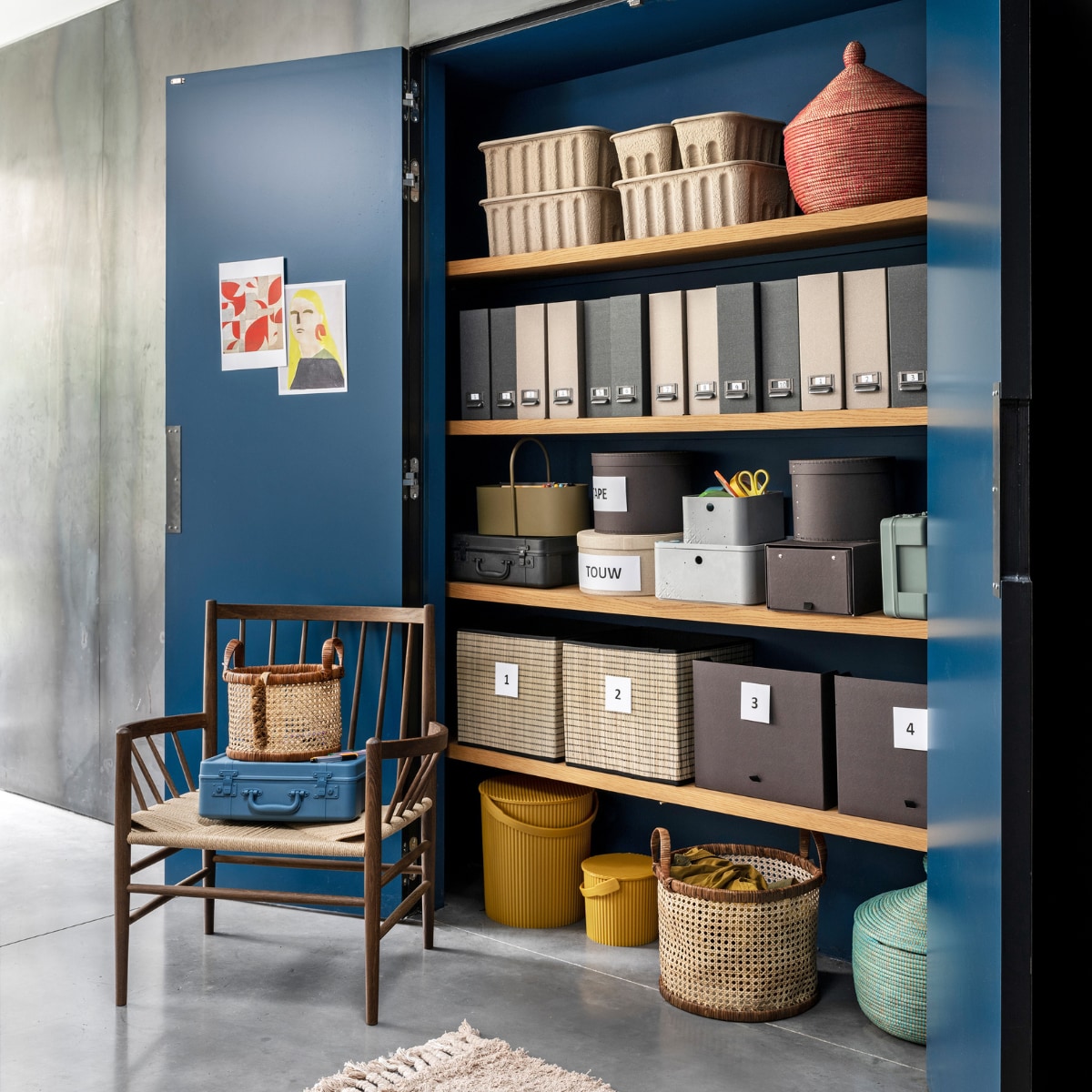 Gele emmers van Hachiman, klein € 16,25, groot € 25,-, olijfkleurige toolbox van Ferm Living € 65,-, betongrijze doos van Curver, medium € 16,15, small € 12,65, deksel medium € 8,90, blauwe en zwarte kunststof koffers van Hachiman, small € 29,95, medium 44,95 (vtwonen.nl). Ronde manden van webbing met leren rand vanaf € 29,99 (hm.com). Naturel ronde doos uit set van 3 € 14,95, donkergrijze ronde dozen, set van 2 € 9,99, uitschuifbare doos voor schoenen € 4,99, lectuurbak Tjog in naturel en donkergrijs, set van 2 € 3,99, rieten inklapbare dozen onderin € 7,99, rechts daarvan doos Anilinare € 5,99 (ikea.nl). Kartonnen dozen van Ferm Living op bovenste plank vanaf € 25,-, loper van Ferm Living € 119,- (misterdesign.nl). Rood-blauwe mand met deksel € 24,95 (basketsbeads- basics.nl). Stoel van FDB Møbler in smoked oak, 76,5x63x85 cm (bxdxh) € 1149,- (eijerkamp.nl). Soortgelijke muurverf T04030, prijs op aanvraag (flexa.nl).