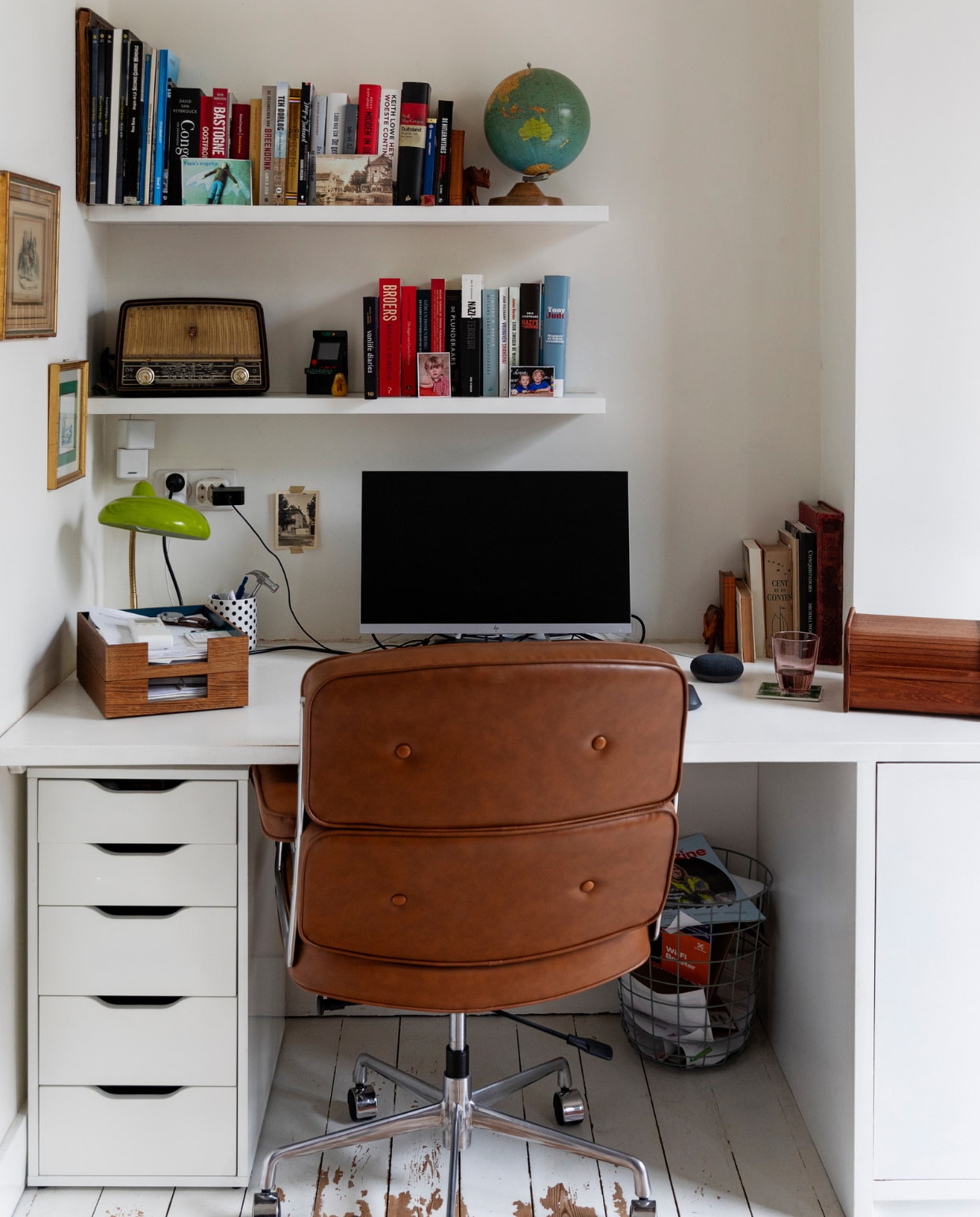 Verf muur en vloer Ral 9010. Bureau en planken op maat laten maken. Globe, schilderijen en bureaulamp rommelmarkt en kringloop. Postvak Ferm Living, bureaustoel Cavel Design. Overig onbekend. vtwonen 10-2023 | styling Ilona Jongepier | fotografie Dana van Leeuwen