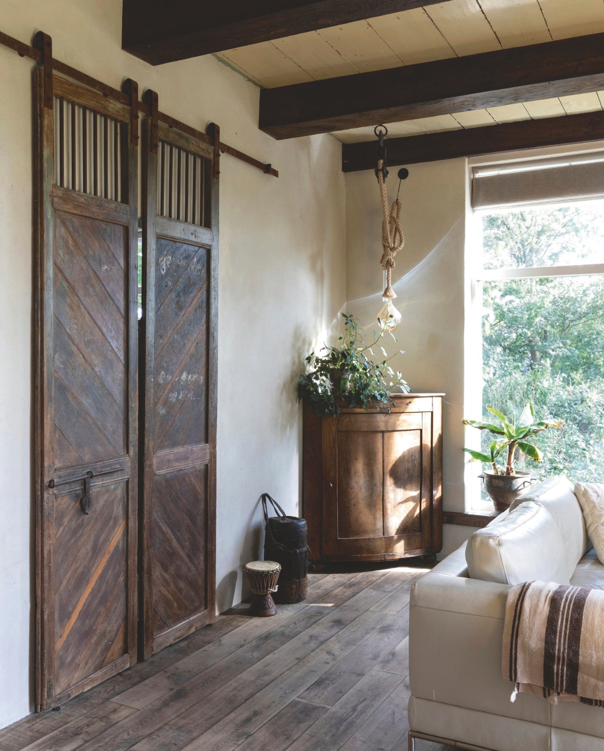 Vintage deuren als schuifdeuren. Onderdelen voor de schuifconstructie via barnwoodweb.nl. Soortgelijke houten vloer bij ’t Achterhuis. vtwonen landelijk 01-2025 | productie Taverne Agency | styling en fotografie Tessa Jol