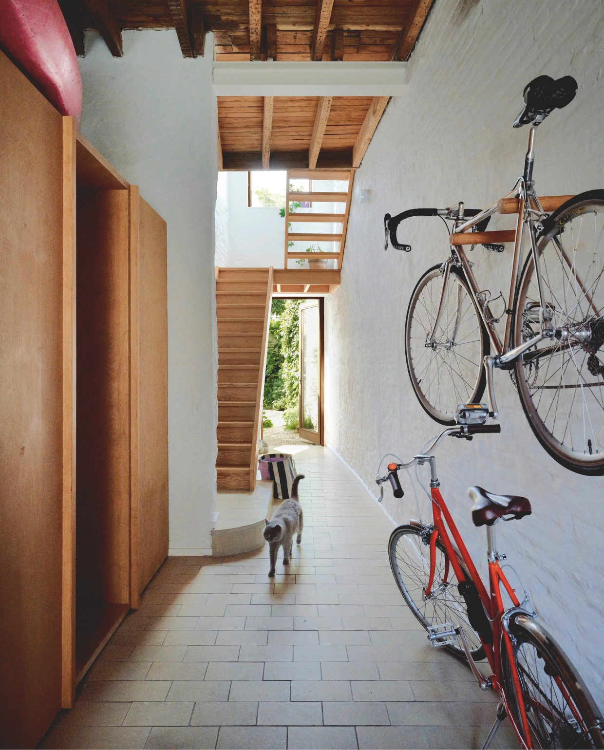 In de hal op de begane grond is plaats voor fietsen. Links achterin bevindt zich de slaapkamer. stijlvol wonen 02-2025 | productie Living Inside | fotografie Mr. Frank