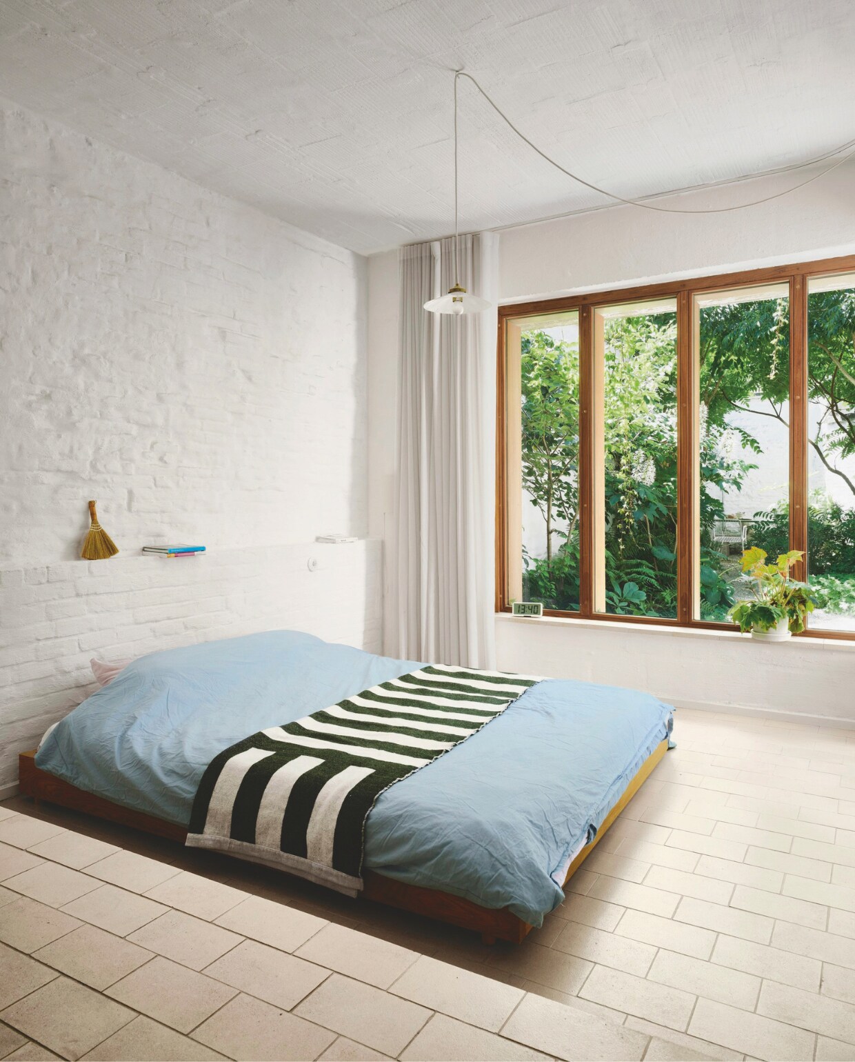 Een aanbouw maakte plaats voor een slaapkamer op de begane grond, met zicht op de weelderige stadstuin. Bed zelfgemaakt, hanglamp Rotor. stijlvol wonen 02-2025 | productie Living Inside | fotografie Mr. Frank