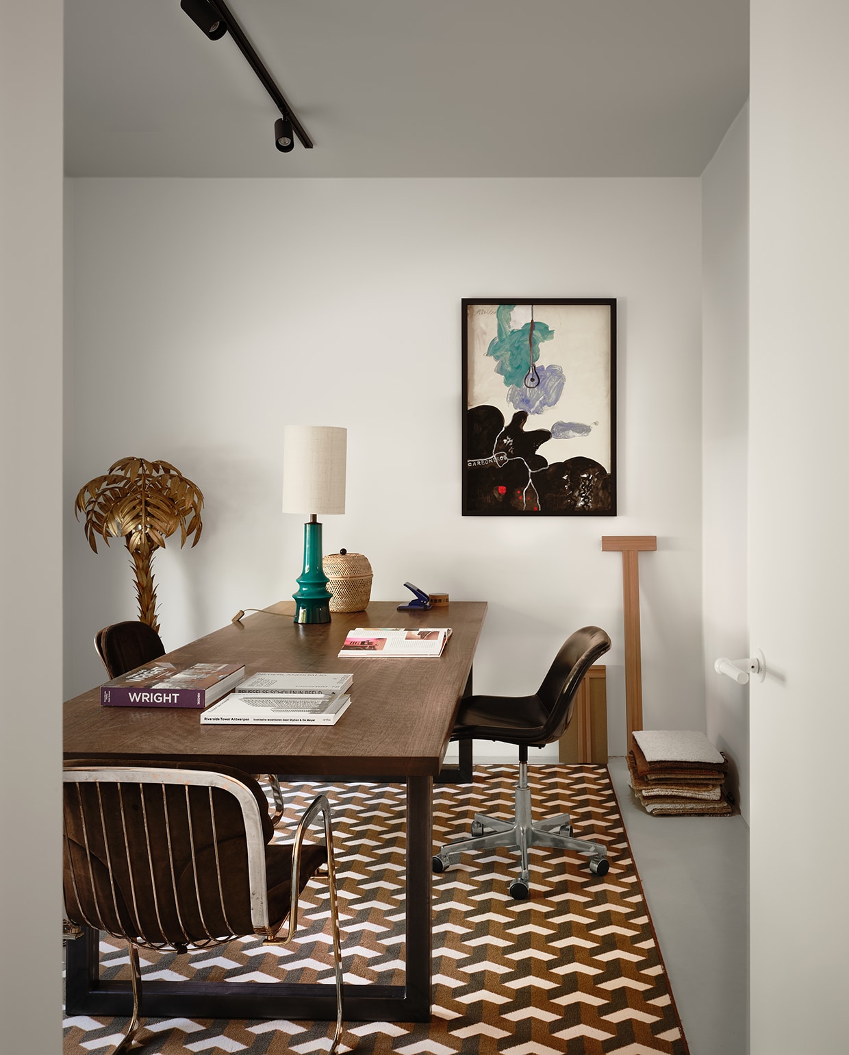 De robuuste tafel van Afrikaanse walnoot, van Heerenhuis, fungeerde eerder als eettafel en kreeg een nieuwe bestemming als bureau. De Spirit Office Chair van Hajima Oonishi voor Houtoku/Artifort is een cadeau van Michelles vader. De Palm Tree lamp en de stoel vooraan, van Willy Rizzo voor Cidue, kreeg ze van haar oma. Het kunstwerk kocht ze op een online veiling als cadeau voor haar man. Het op maat gemaakte tapijt verbindt de oude en nieuwe elementen. stijlvol wonen 2-2025 | fotografie Mr Frank | tekst Maya Toebat